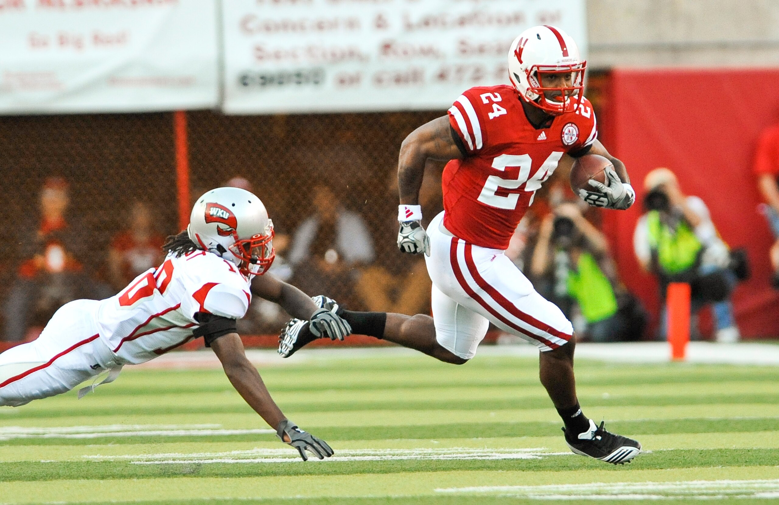 LINCOLN, NE - SEPTEMBER 04:  Jamal Forest #18 of the Western Kentucky Hilltoppers  tries to bring down Niles Paul #24 of the Nebraska Cornhuskers during first half action of their game at Memorial Stadium on September 4, 2010 in Lincoln, Nebraska.  Nebras