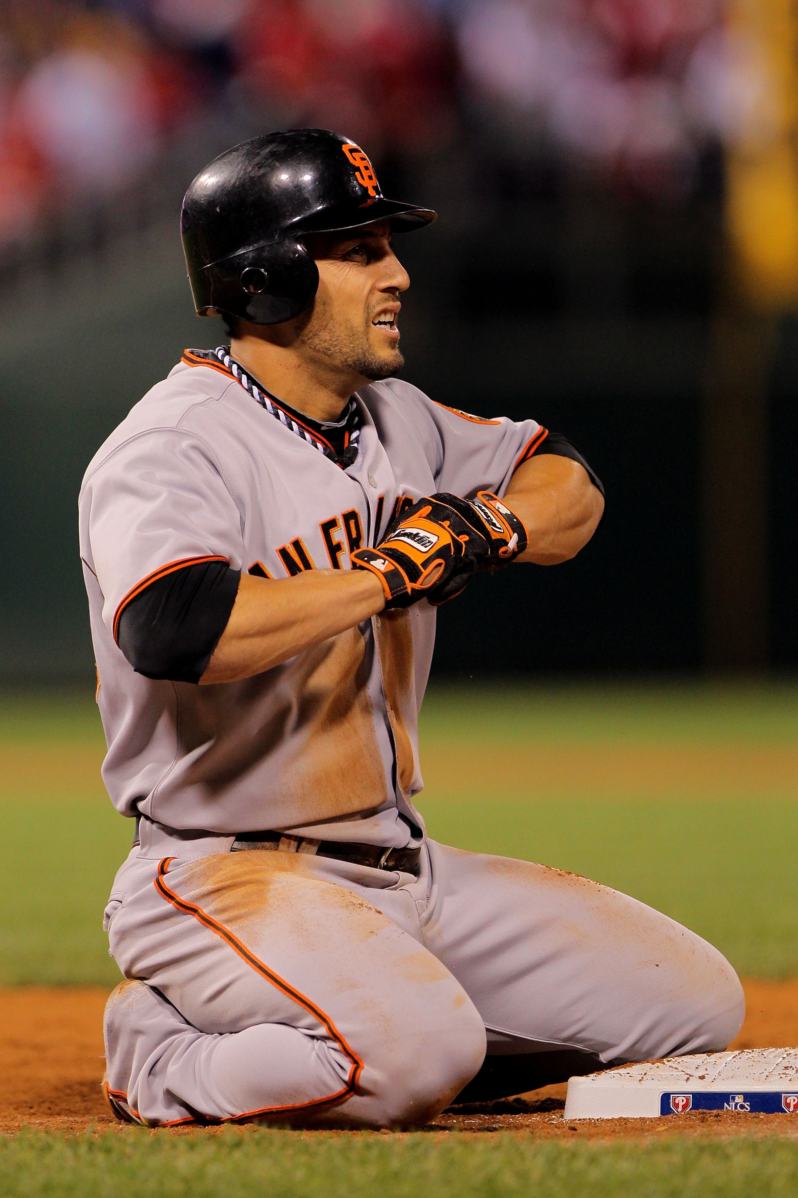 PHILADELPHIA - OCTOBER 23:  Andres Torres #56 of the San Francisco Giants kneels at first after diving back to first base for a single against the Philadelphia Phillies in Game Six of the NLCS during the 2010 MLB Playoffs at Citizens Bank Park on October