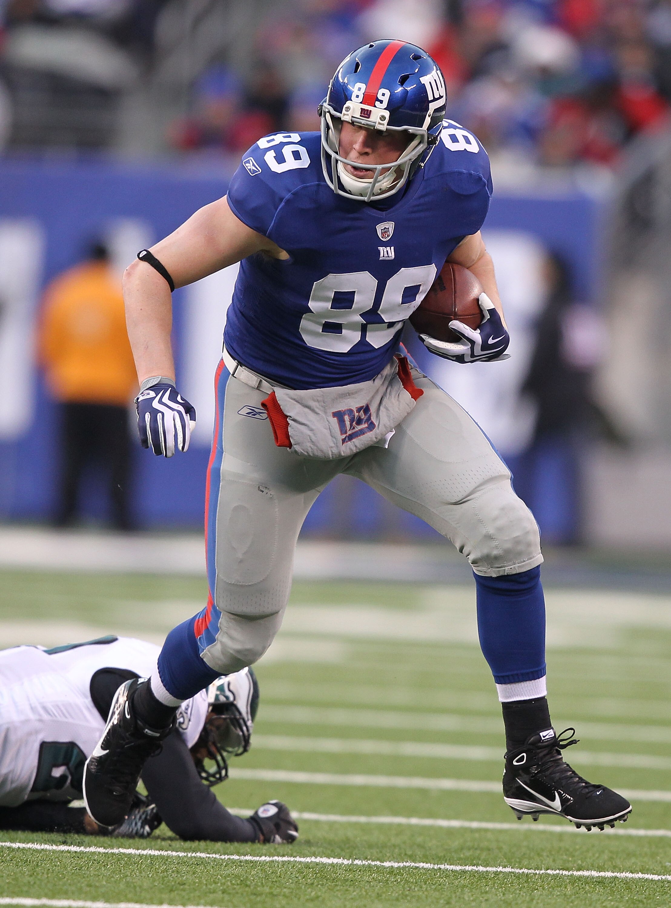EAST RUTHERFORD, NJ - DECEMBER 19:  Kevin Boss #89 of the New York Giants eludes the tackle of Quintin Mikell #27 of the Philadelphia Eagles during their game on December 19, 2010 at The New Meadowlands Stadium in East Rutherford, New Jersey.  (Photo by A