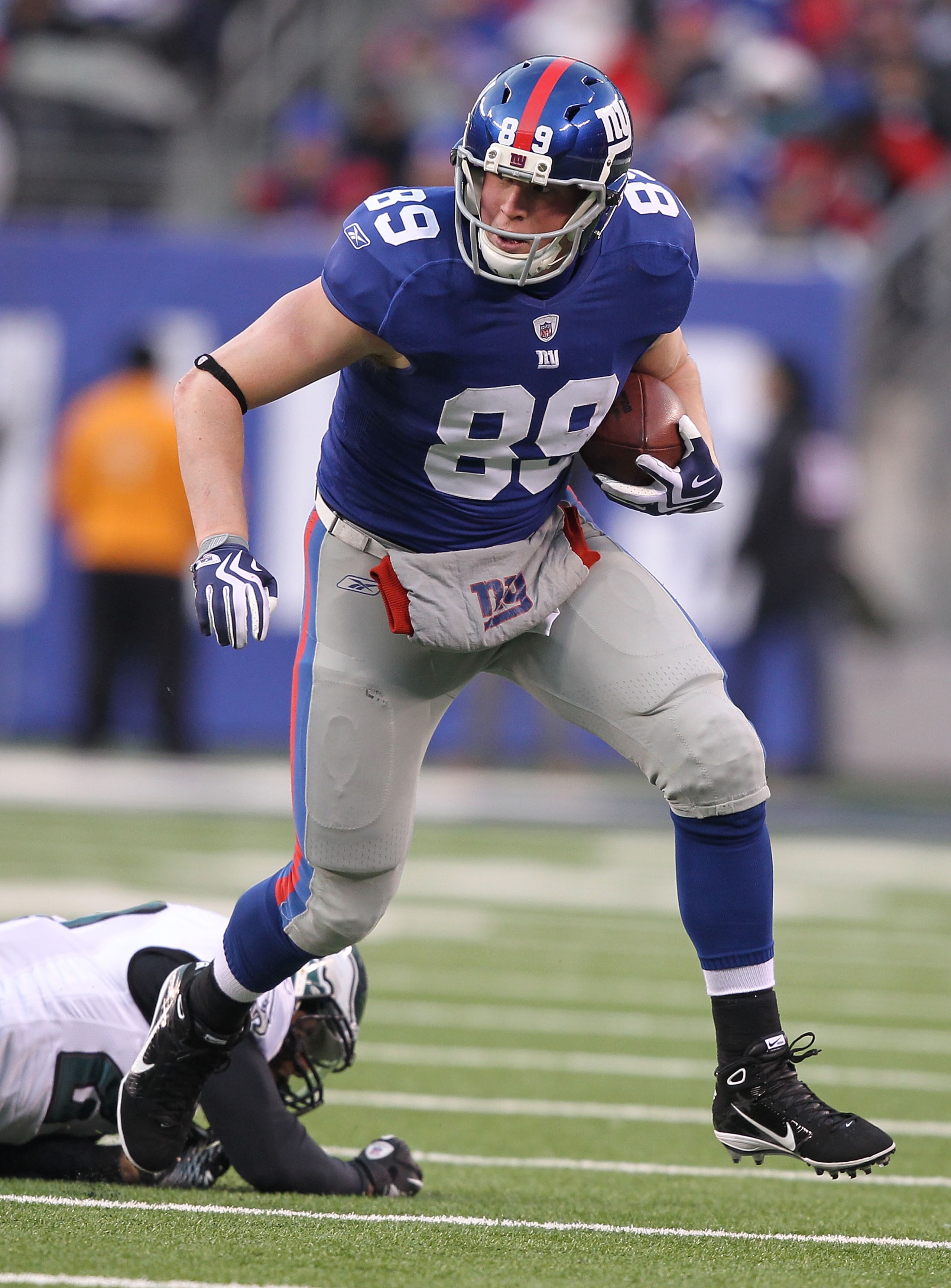 EAST RUTHERFORD, NJ - DECEMBER 19:  Kevin Boss #89 of the New York Giants eludes the tackle of Quintin Mikell #27 of the Philadelphia Eagles during their game on December 19, 2010 at The New Meadowlands Stadium in East Rutherford, New Jersey.  (Photo by A