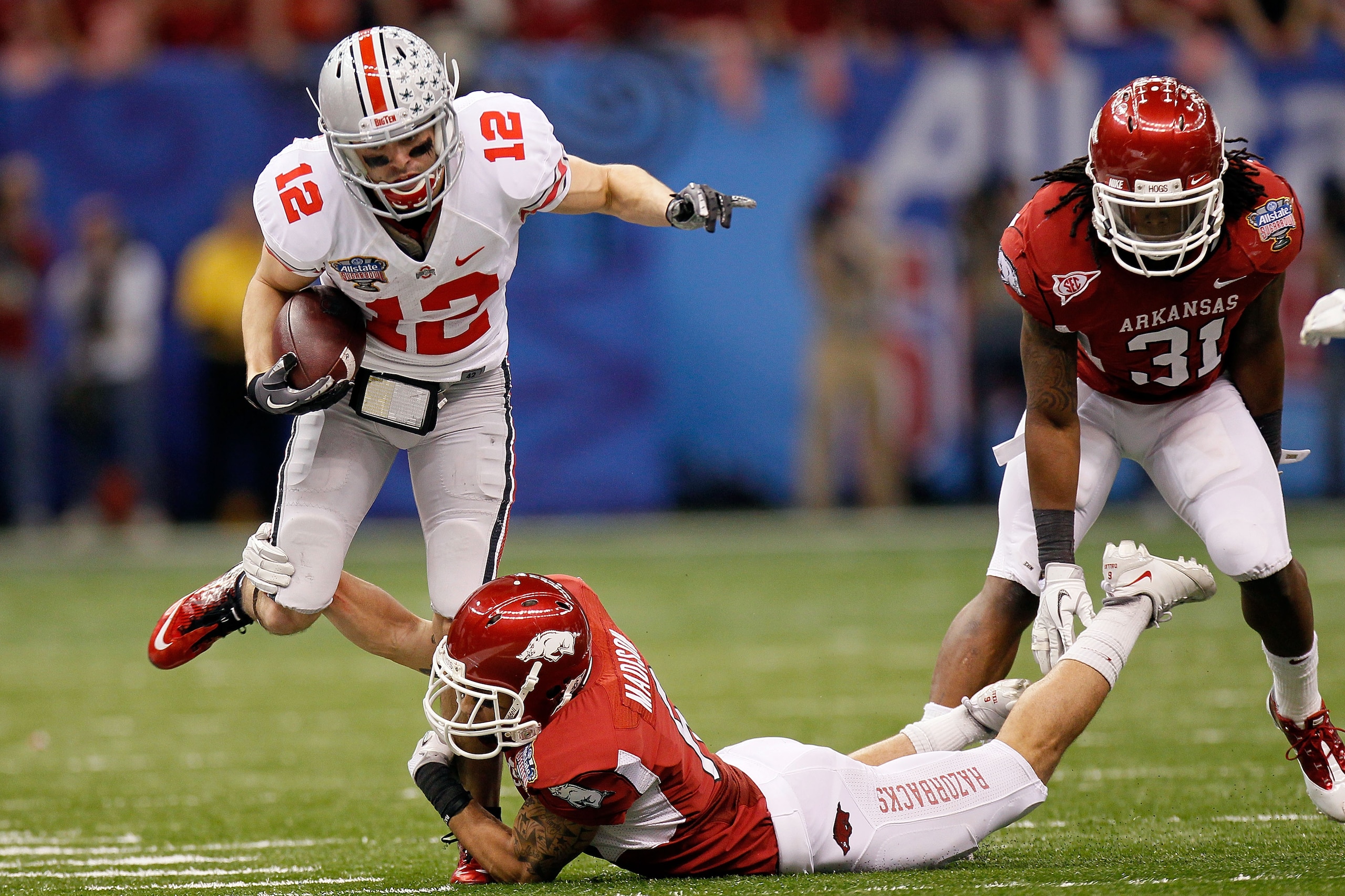 NEW ORLEANS, LA - JANUARY 04:  Dane Sanzenbacher #12 of the Ohio State Buckeyes runs after a catch against Isaac Madison #6 of the Arkansas Razorbacks in the second quarter during the Allstate Sugar Bowl at the Louisiana Superdome on January 4, 2011 in Ne