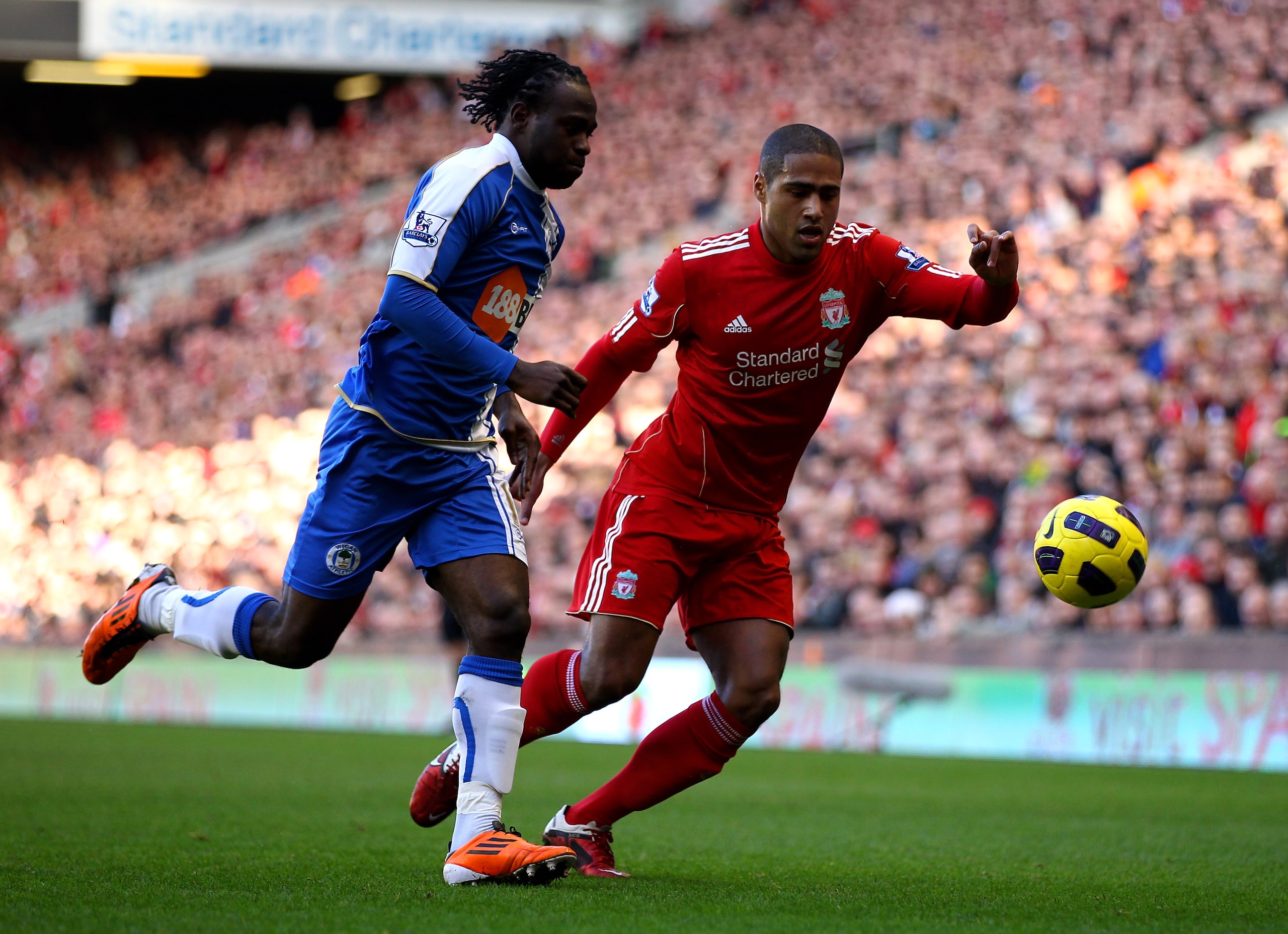 LIVERPOOL, ENGLAND - FEBRUARY 12:  Victor Moses of Wigan Athletic competes with Glen Johnson of Liverpool during the Barclays Premier League match between Liverpool and Wigan Athletic at Anfield on February 12, 2011 in Liverpool, England.  (Photo by Clive