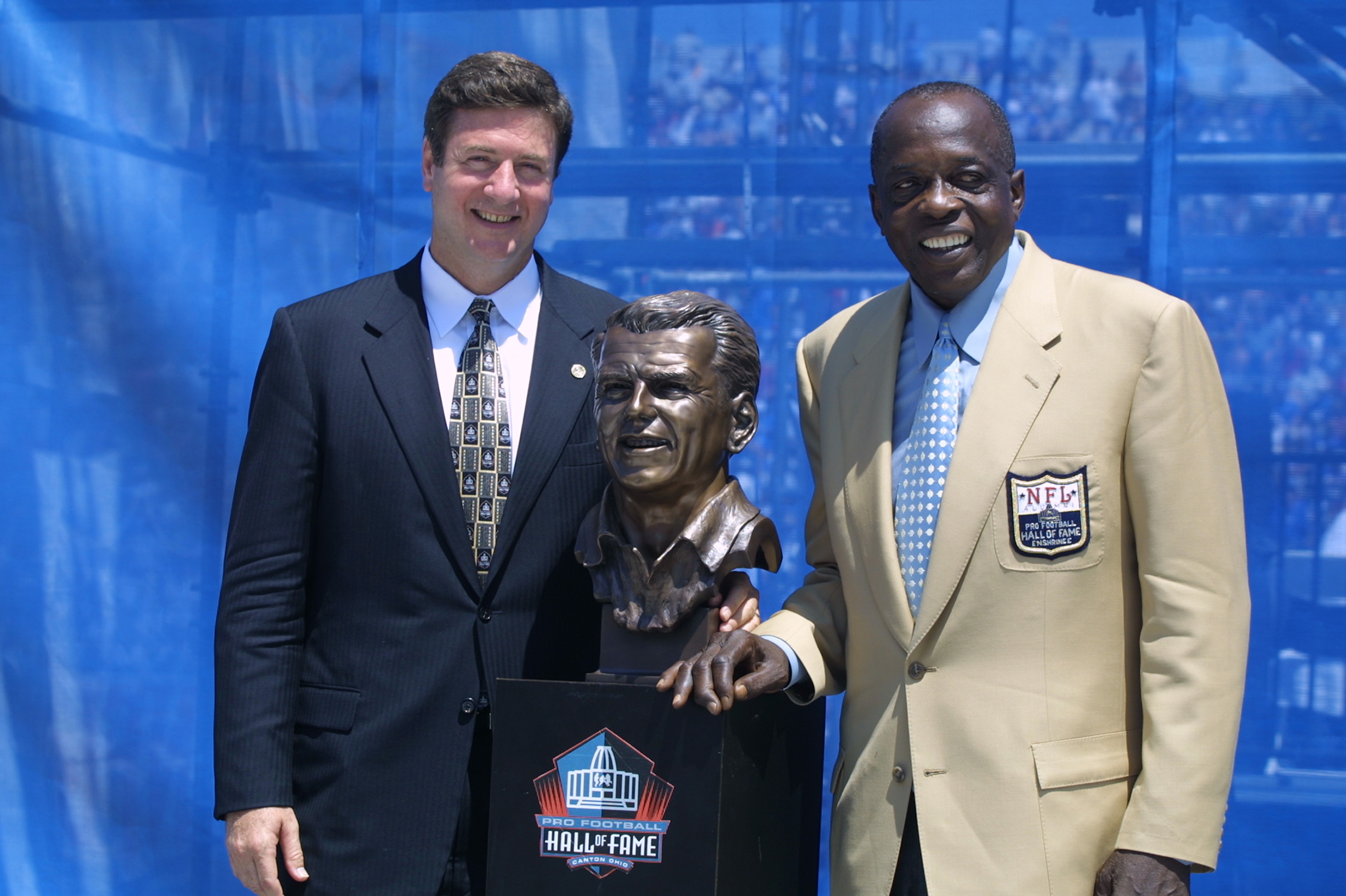 CANTON, OHIO - AUGUST 3:  Virginia Senator George Allen (left) stands next to a bust in the likeness of his father, Coach George Allen with his presenter Deacon Jones after Coach Allen's induction into the National Football League Hall of Fame on August 3
