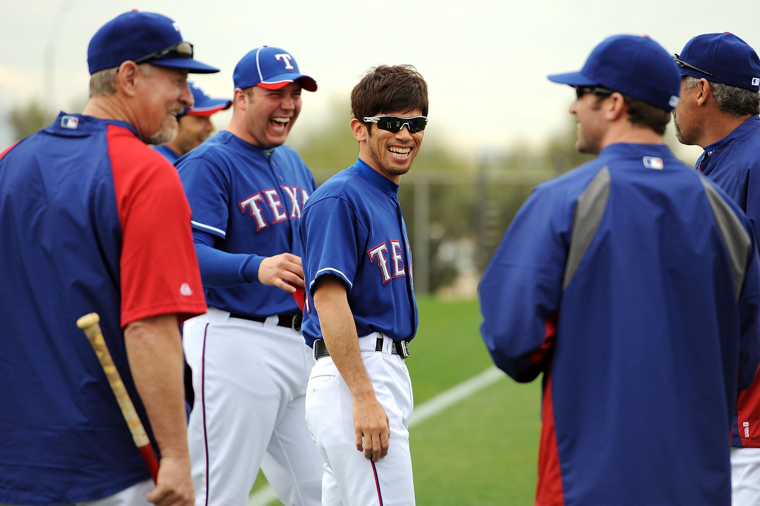 SURPRISE, AZ - FEBRUARY 18:  Yoshinori Tateyama #22 of the Texas Rangers laughs with some of his teammates prior to pratice at Surprise Stadium on February 18, 2011 in Surprise, Arizona.  (Photo by Norm Hall/Getty Images)