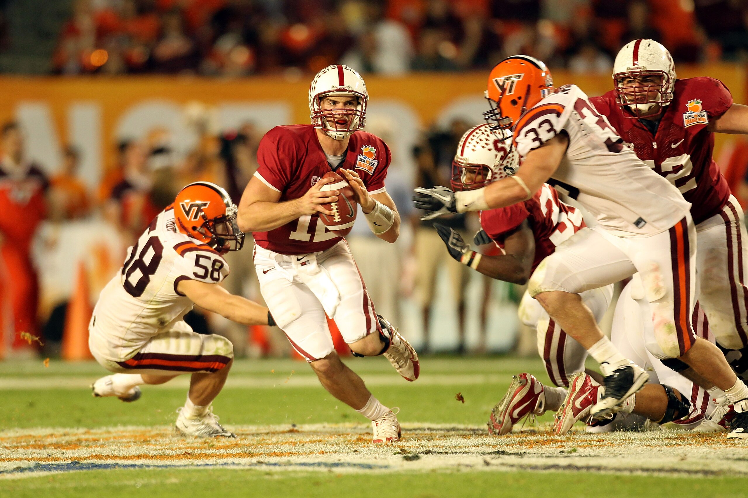 MIAMI, FL - JANUARY 03:  Andrew Luck #12 of the Stanford Cardinal looks to pass under pressure from Chris Drager #33 and Jack Tyler #58 of the Virginia Tech Hokies during the 2011 Discover Orange Bowl at Sun Life Stadium on January 3, 2011 in Miami, Flori