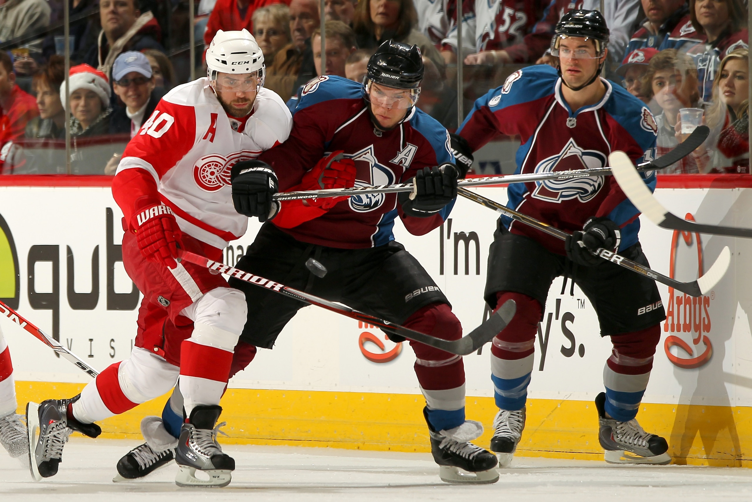 DENVER - DECEMBER 27:  Henrik Zetterberg #40 of the Detroit Red Wings and Paul Stastny #26 of the Colorado Avalanche battle for the puck as TJ Galiardi #39 of the Avalanche follows the play at the Pepsi Center on December 27, 2010 in Denver, Colorado.  (P