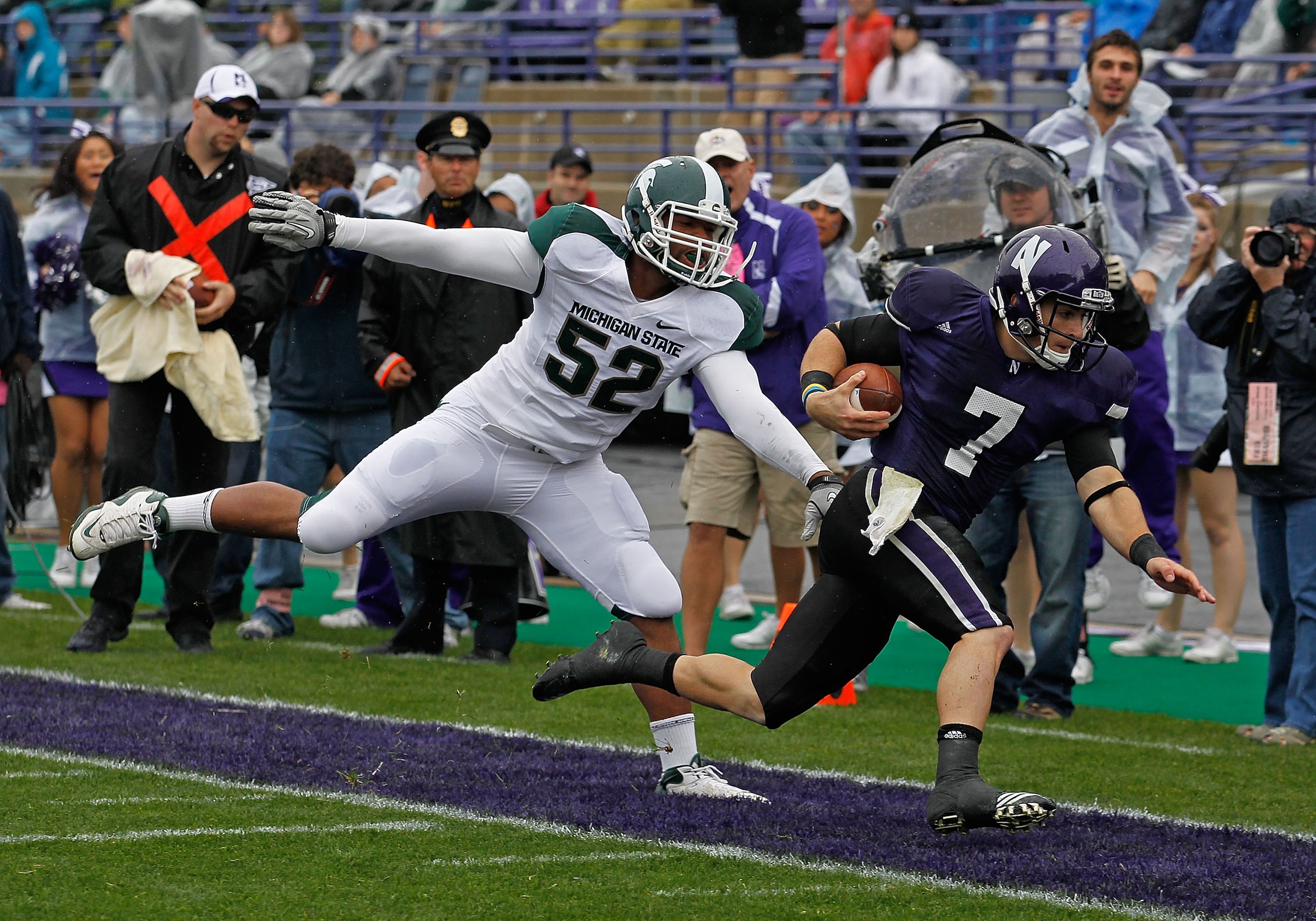 EVANSTON, IL - OCTOBER 23: Dan Persa #7 of the Northwestern Wildcats is knocked out of bounds short of the goalline by Denzel Drone #52 of the Michigan State Spartans at Ryan Field on October 23, 2010 in Evanston, Illinois. Michigan State defeated Northwe