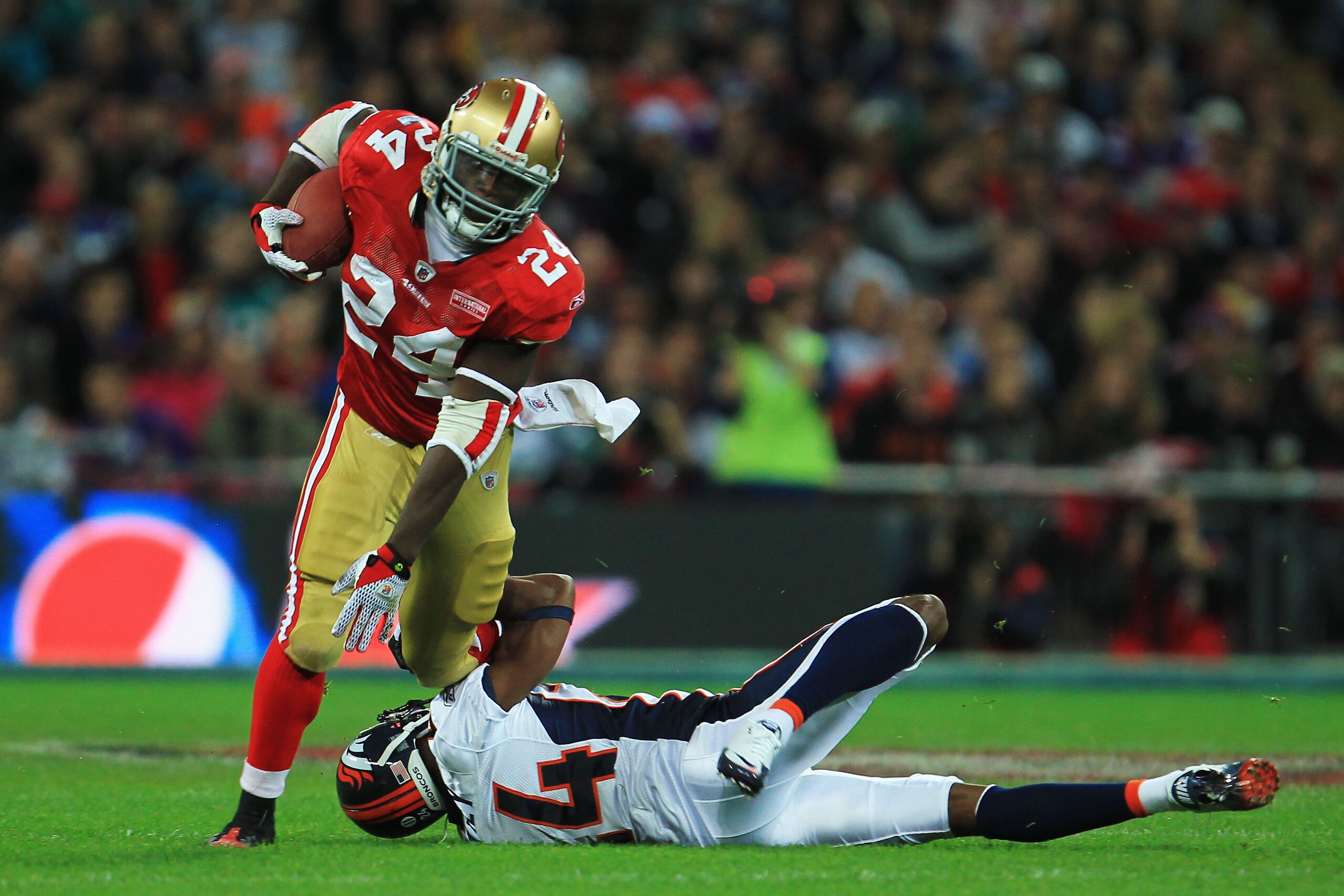 LONDON, ENGLAND - OCTOBER 31:  Anthony Dixon #24 of San Francisco 49ers is tackled by Champ Bailey #24 of Denver Broncos during the NFL International Series match between Denver Broncos and San Francisco 49ers at Wembley Stadium on October 31, 2010 in Lon