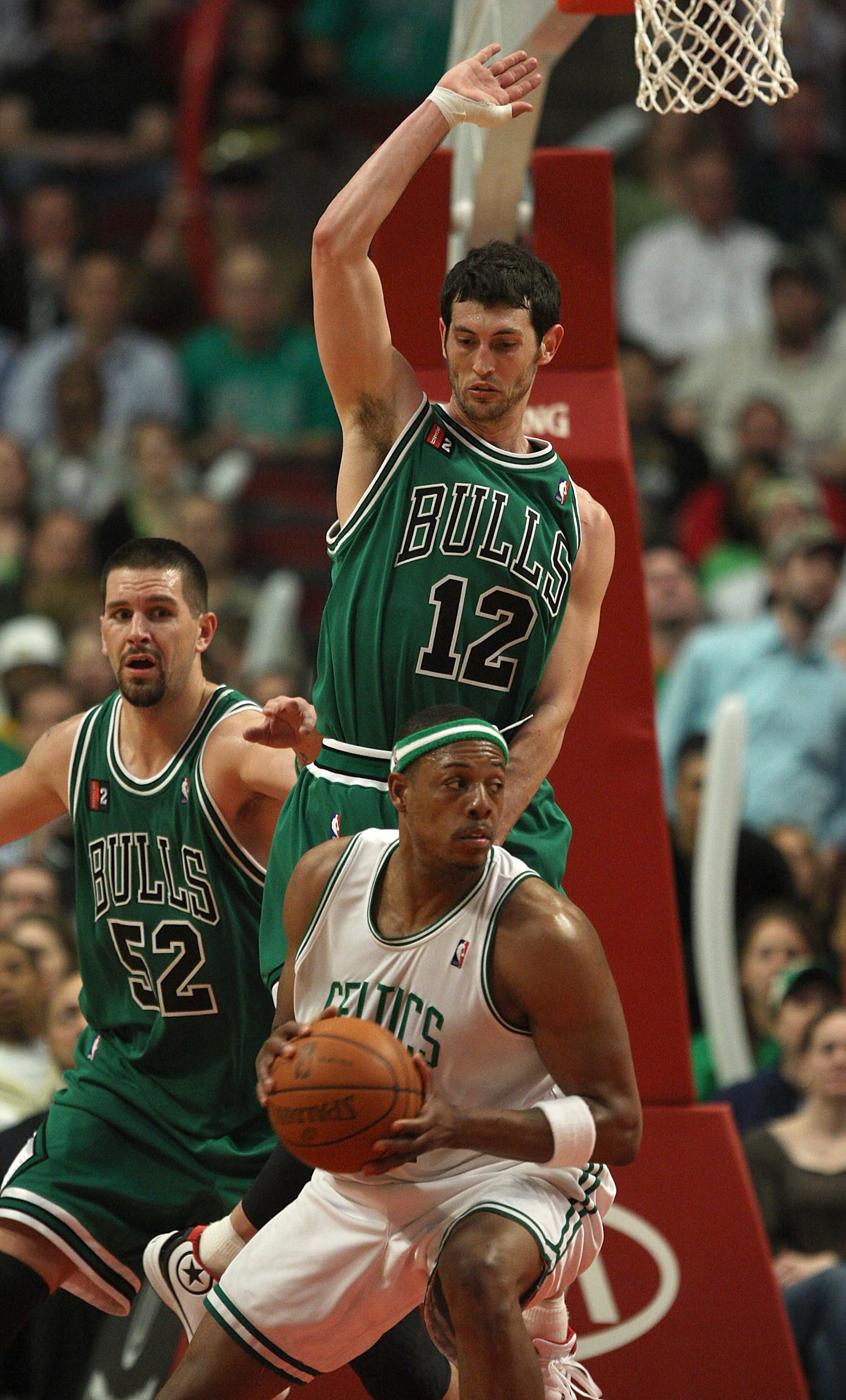 CHICAGO - MARCH 17: Kirk Hinrich #12 of the Chicago Bulls jumps to defend against Paul Pierce #34 of the Boston Celtics as Brad Miller #52 assists on March 17, 2009 at the United Center in Chicago, Illinois. The Bulls defeated the Celtics 127-121. NOTE TO
