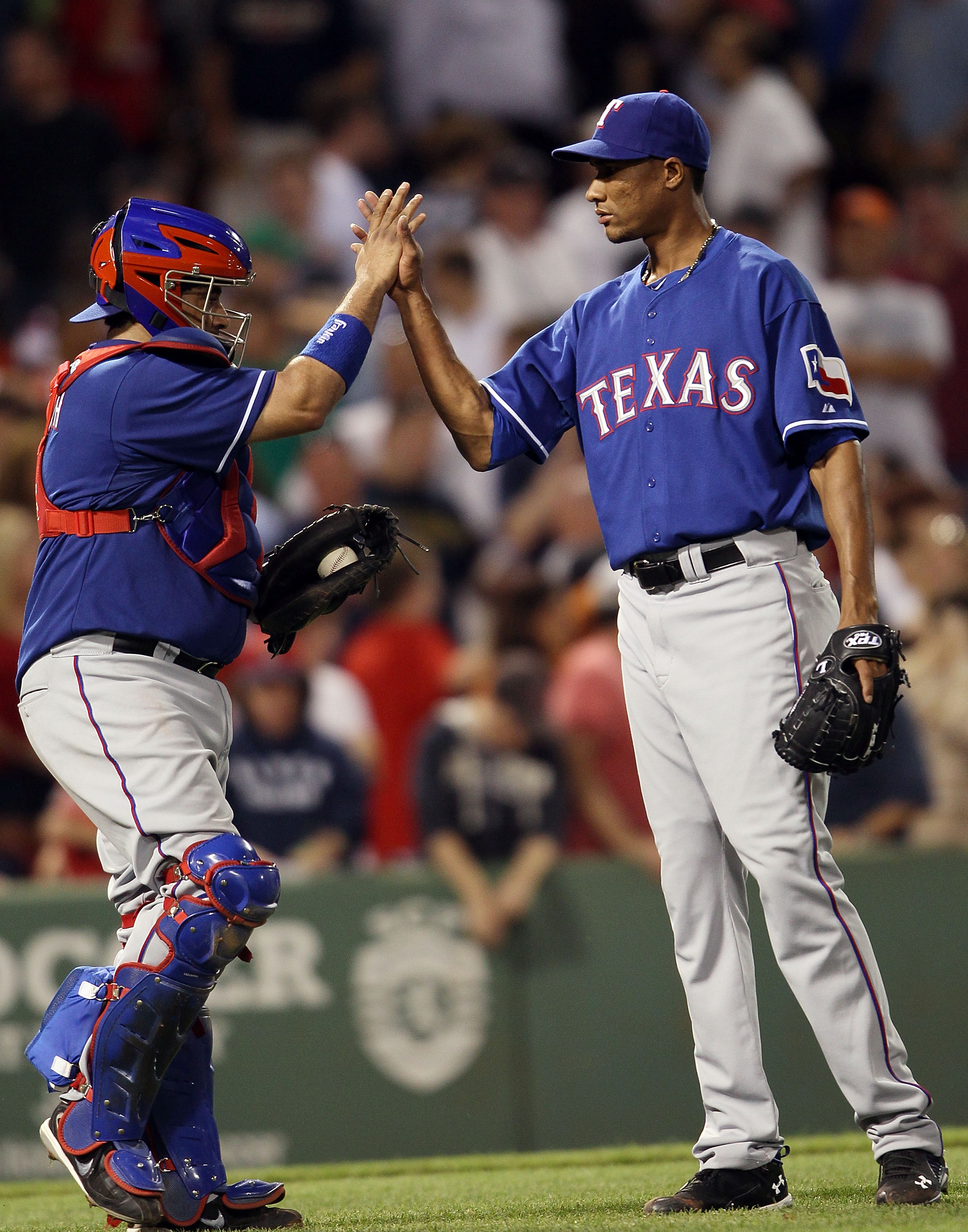 BOSTON - JULY 15:  Alexi Orgando #64 and Bengie Molina #11 of the Texas Rangers celebrate the win over the Boston Red Sox on July 15, 2010 at Fenway Park in Boston, Massachusetts. The Rangers defeated the Red Sox 7-2.  (Photo by Elsa/Getty Images)