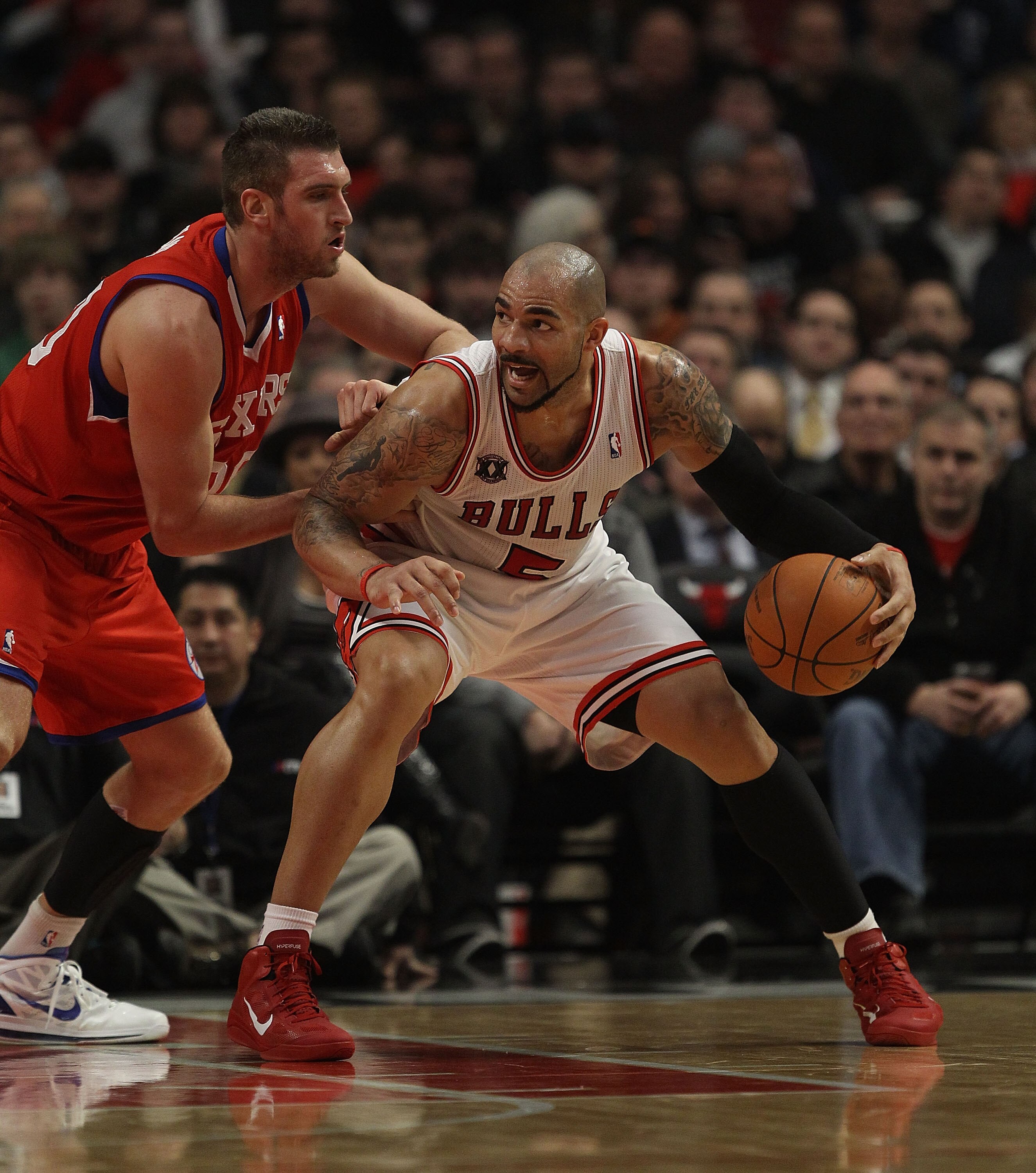 CHICAGO, IL - DECEMBER 21: Carlos Boozer #5 of the Chicago Bulls moves against Spencer Hawes #00 of the Philadelphia 76ers at the United Center on December 21, 2010 in Chicago, Illinois. The Bulls defeated the 76ers 121-76. NOTE TO USER: User expressly ac