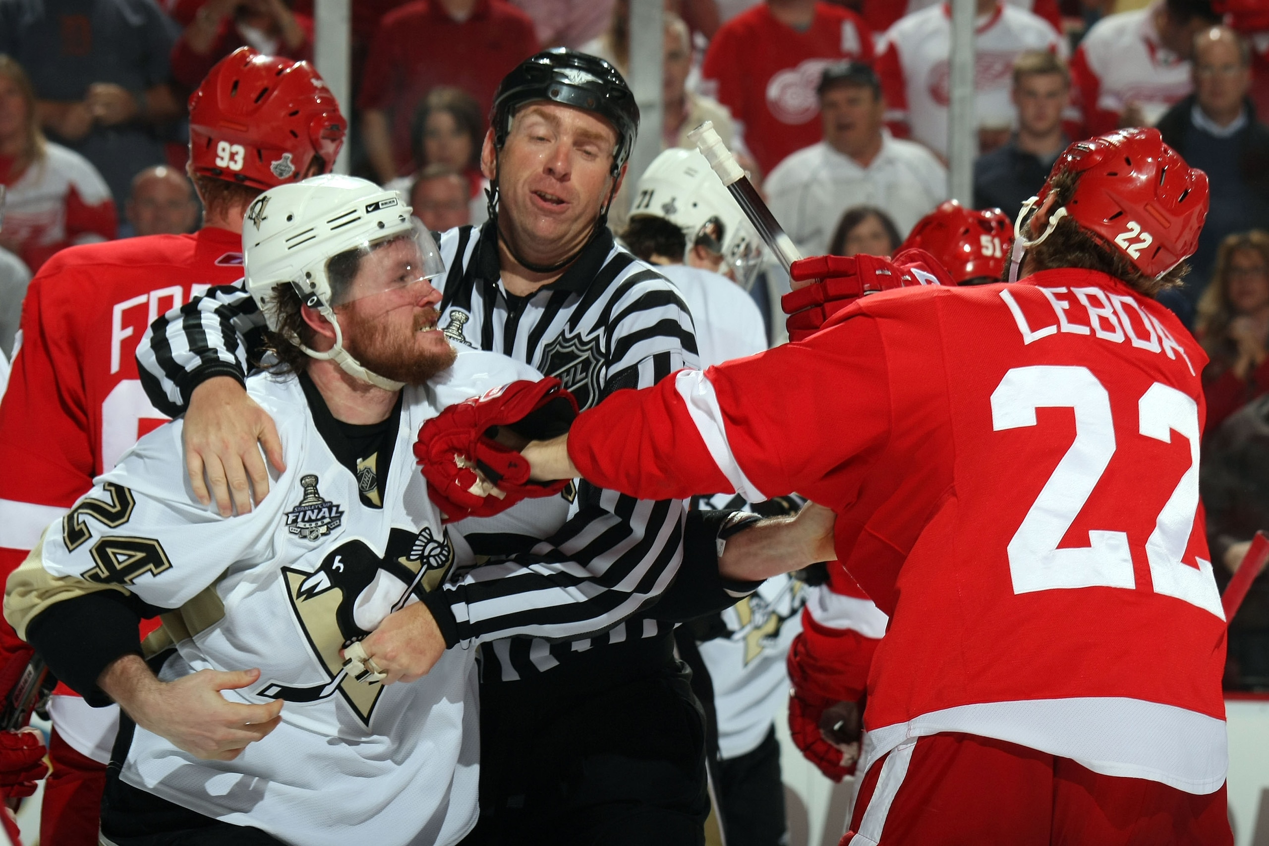 DETROIT - JUNE 06:  Linesman Pierre Racicot breaks up a scuffle between Matt Cooke #24 of the Pittsburgh Penguins and Brett Lebda #22 of the Detroit Red Wings during Game Five of the 2009 NHL Stanley Cup Finals at Joe Louis Arena on June 6, 2009 in Detroi