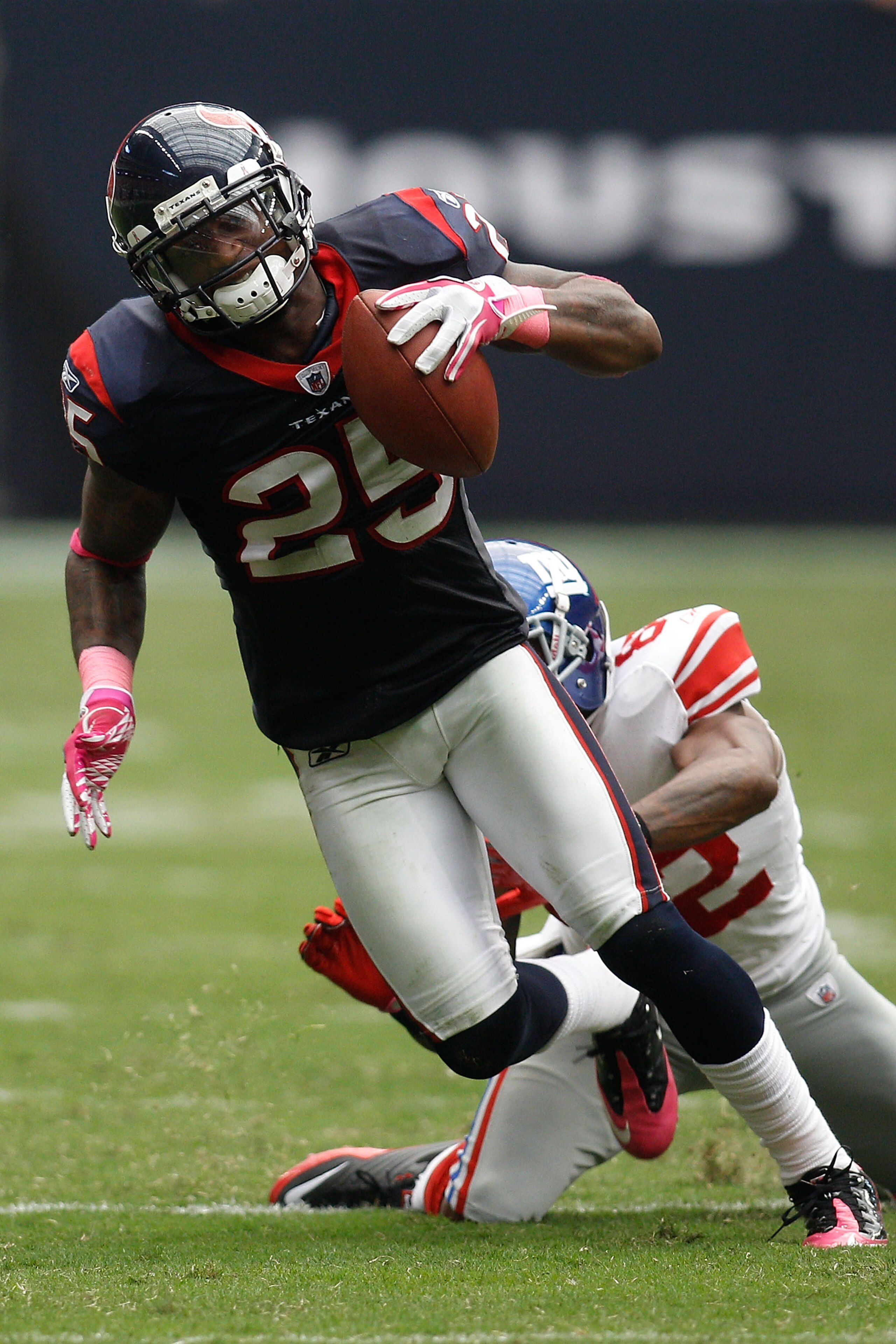 HOUSTON - OCTOBER 10:  Kareem Jackson #25 of the Houston Texans avoids a tackle after intercepting a pass  by Mario Manningham #82 of the New York Giants at Reliant Stadium on October 10, 2010 in Houston, Texas.  The Giants defeated the Texans 34-10.  (Ph