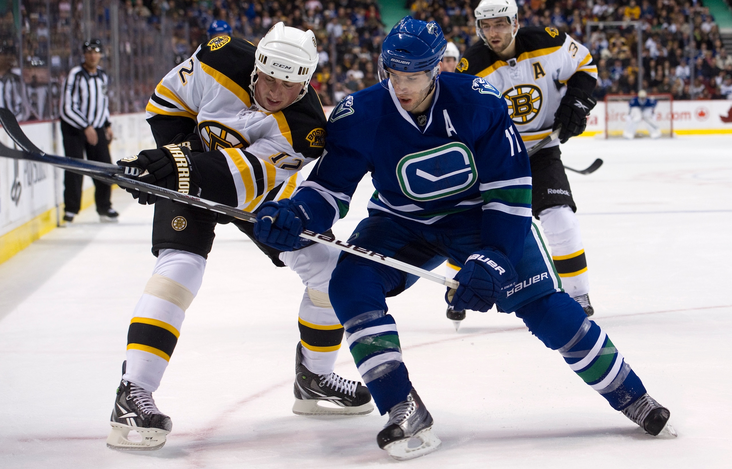 VANCOUVER, CANADA - FEBRUARY 26: Ryan Kesler #17 of the Vancouver Canucks battles with Tomas Kaberle #12 of the Boston Bruins while in the corner during the second period in NHL action on February 26, 2011 at Rogers Arena in Vancouver, British Columbia, C