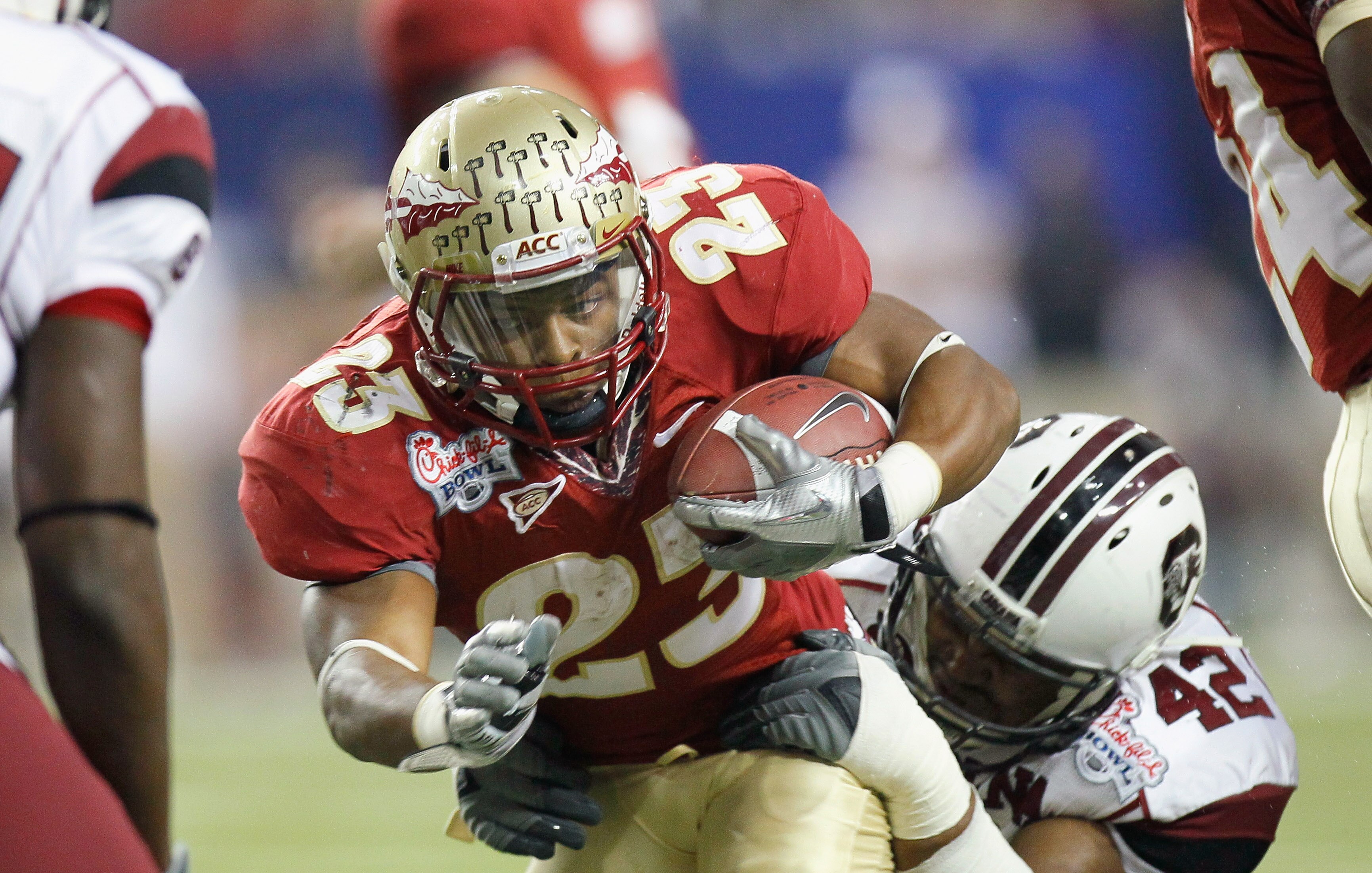 ATLANTA, GA - DECEMBER 31:  Chris Thompson #23 of the Florida State Seminoles is tackled by Travian Robertson #42 of the South Carolina Gamecocks during the 2010 Chick-fil-A Bowl at Georgia Dome on December 31, 2010 in Atlanta, Georgia.  (Photo by Kevin C