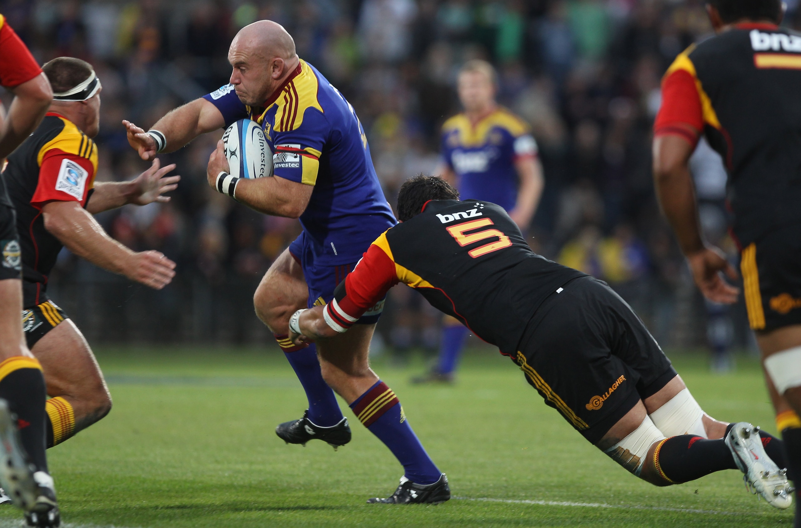 DUNEDIN, NEW ZEALAND - FEBRUARY 25: Jason Rutledge of the Highlanders is tackled by Issac Ross of the Chiefs during the round two Super Rugby match between the Highlanders and the Chiefs at Carisbrook on February 25, 2011 in Dunedin, New Zealand.  (Photo