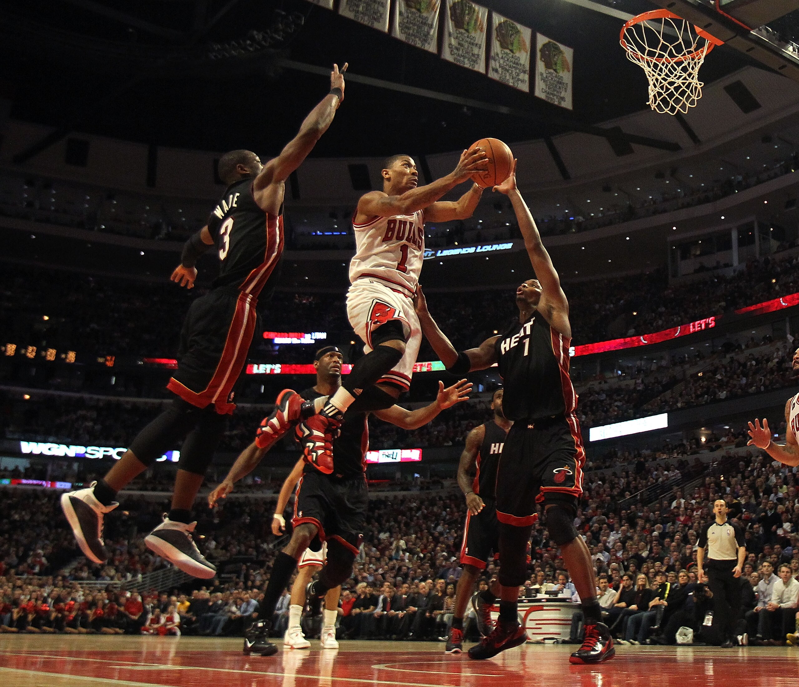 CHICAGO, IL - FEBRUARY 24: Derrick Rose #1 of the Chicago Bulls puts up a shot between Dwyane Wade #3 and Chris Bosh #1 of the Miami Heat at the United Center on February 24, 2011 in Chicago, Illinois. The Bulls defeated the Heat 93-89. NOTE TO USER: User