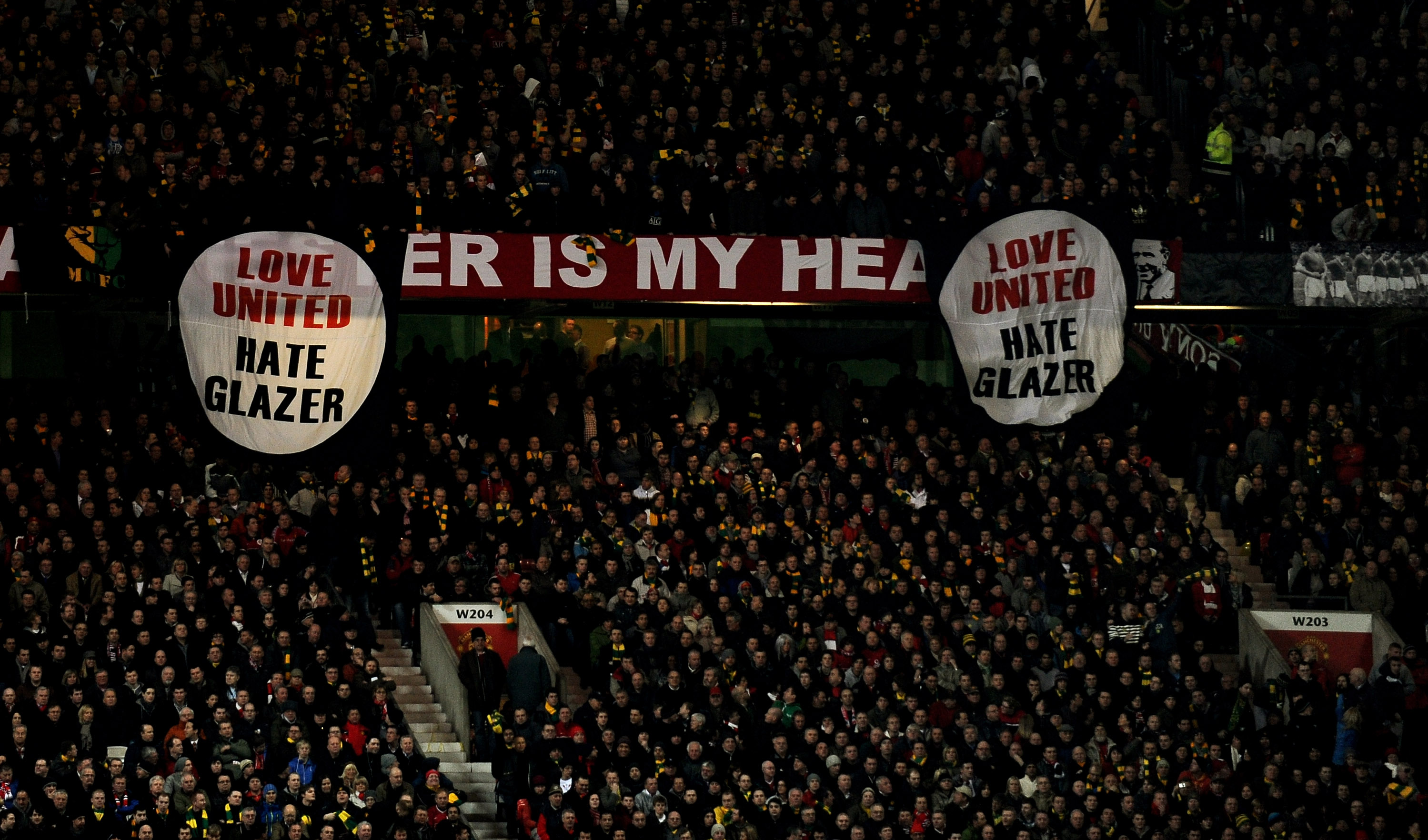 MANCHESTER, ENGLAND - MARCH 10: Manchester United fans reveal anti Glazer banners during the UEFA Champions League First Knockout Round, second leg match between Manchester United and AC Milan at Old Trafford on March 10, 2010 in Manchester, England. (Pho