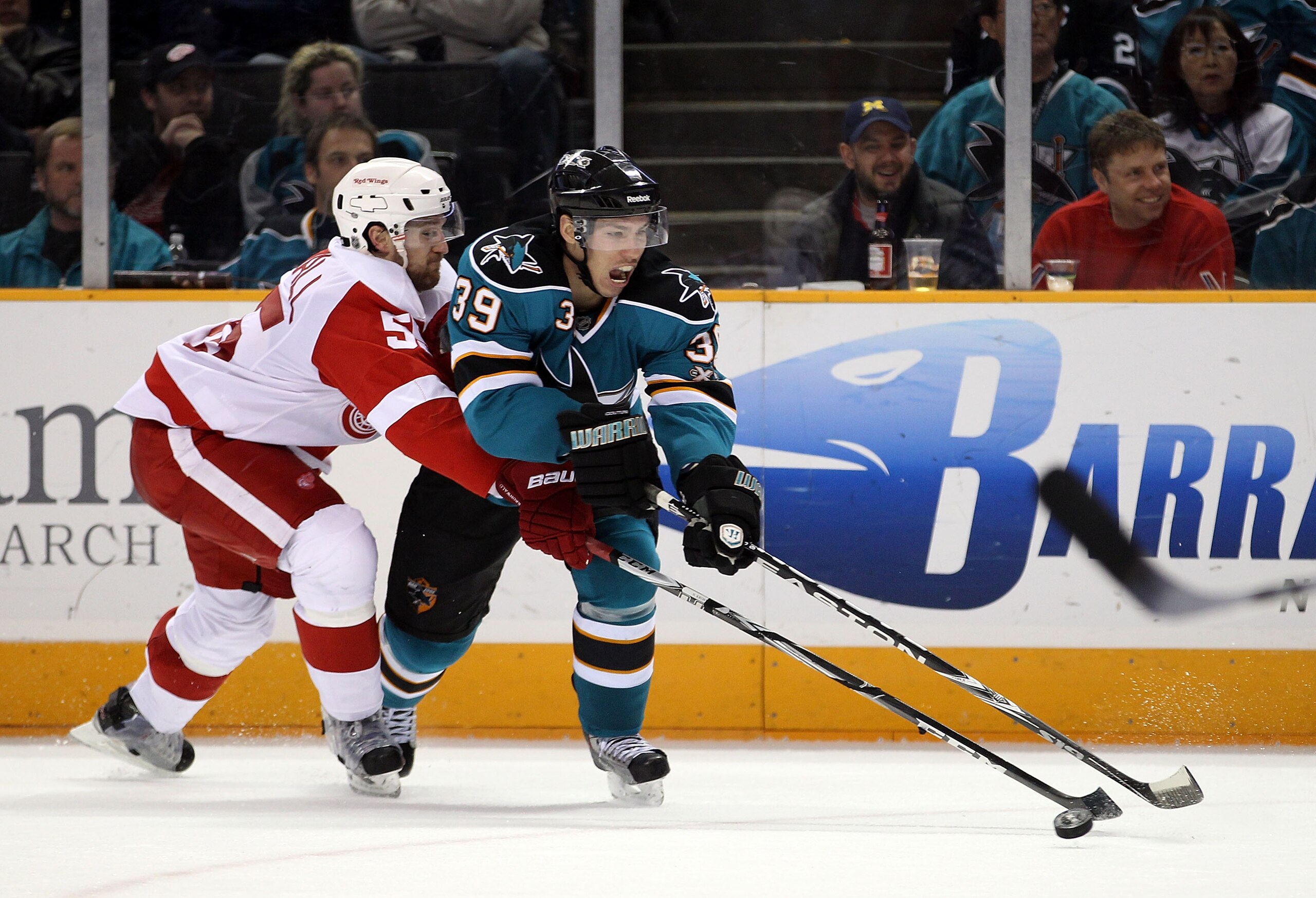 SAN JOSE, CA - NOVEMBER 30:  Niklas Kronwall #55 of the Detroit Red Wings and Logan Couture #39 of the San Jose Sharks go for the puck at HP Pavilion on November 30, 2010 in San Jose, California.  (Photo by Ezra Shaw/Getty Images)