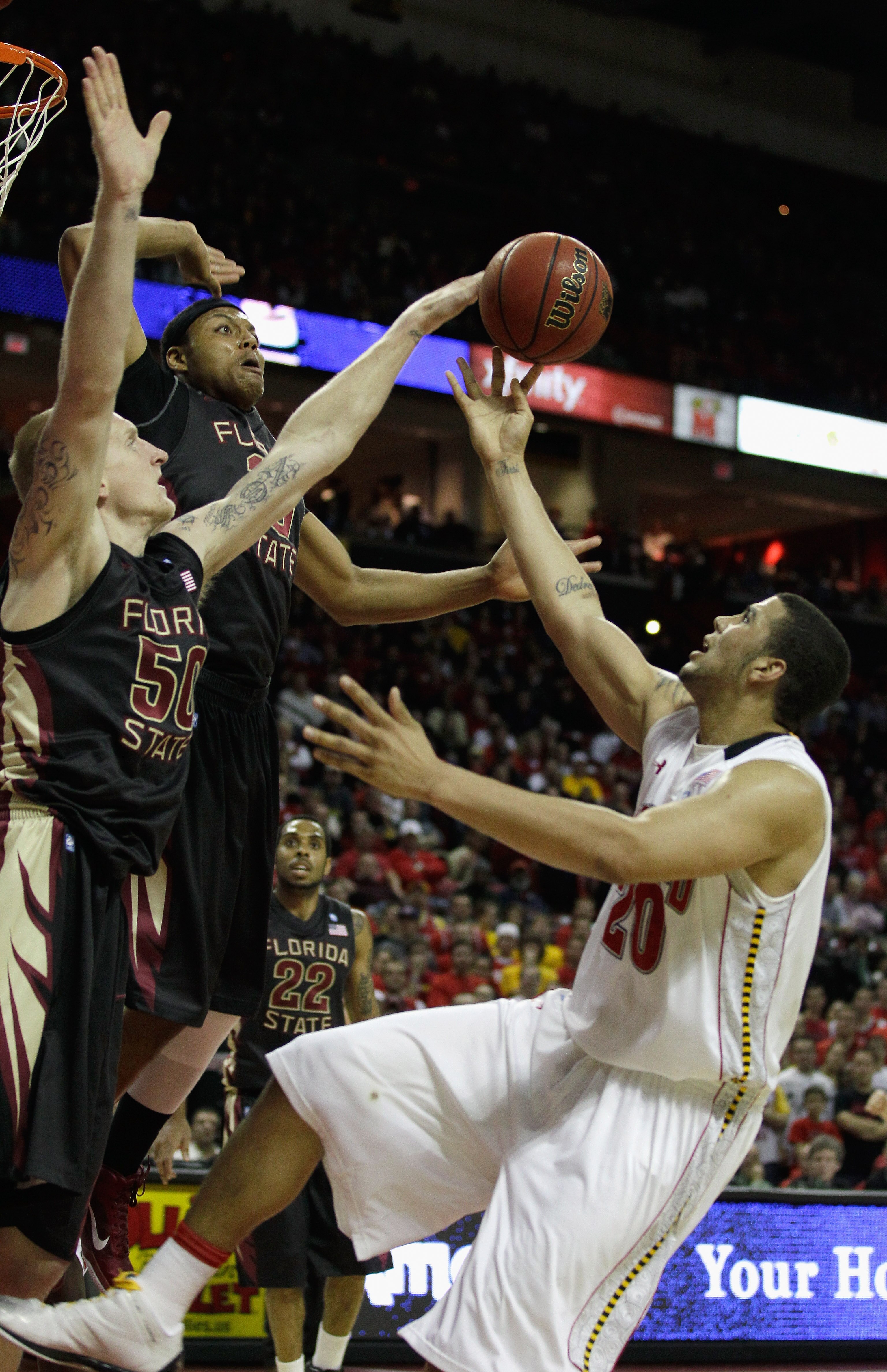 COLLEGE PARK, MD - FEBRUARY 23: Jordan Williams #20 of the  Maryland Terrapins puts up a shot against Jon Kreft #50 and Terrance Shannon, center, of the Florida State Seminoles at the Comast Center on February 23, 2011 in College Park, Maryland.  (Photo b
