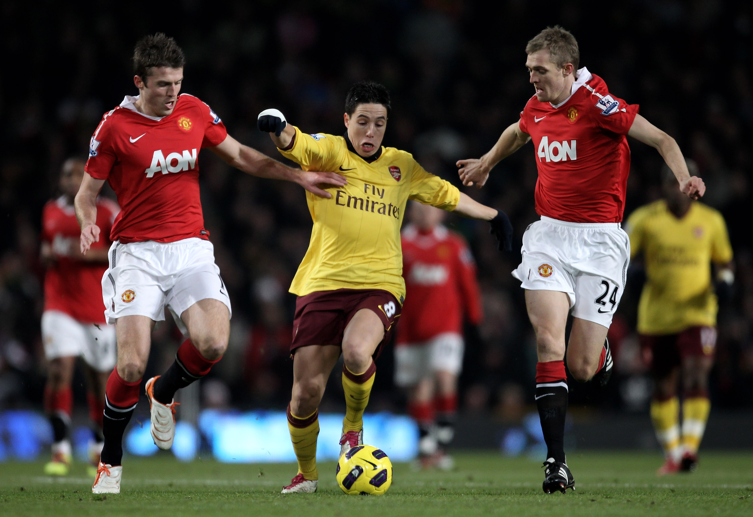 MANCHESTER, ENGLAND - DECEMBER 13:  Samir Nasri of Arsenal competes with Darren Fletcher (R) and Michael Carrick of Manchester United during the Barclays Premier League match between Manchester United and Arsenal at Old Trafford on December 13, 2010 in Ma