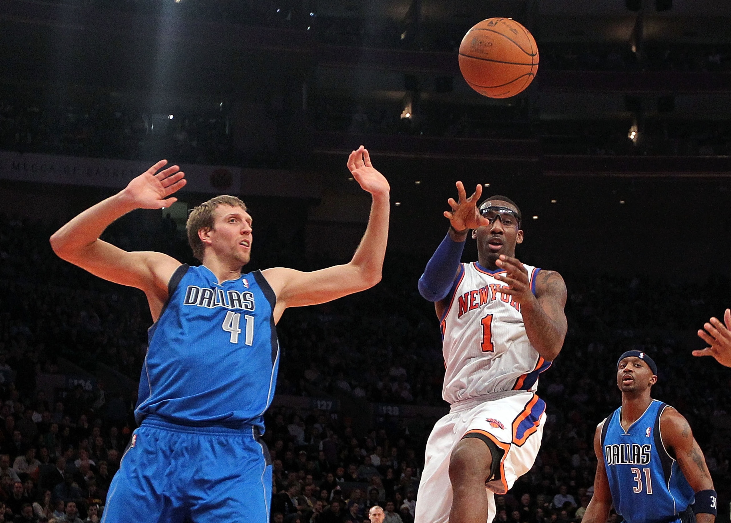 NEW YORK, NY - FEBRUARY 02:  Amar'e Stoudemire #1 of the New York Knicks passes the ball in front of Dirk Nowitzki #41 of the Dallas Mavericks at Madison Square Garden on February 2, 2011 in New York City. NOTE TO USER: User expressly acknowledges and agr