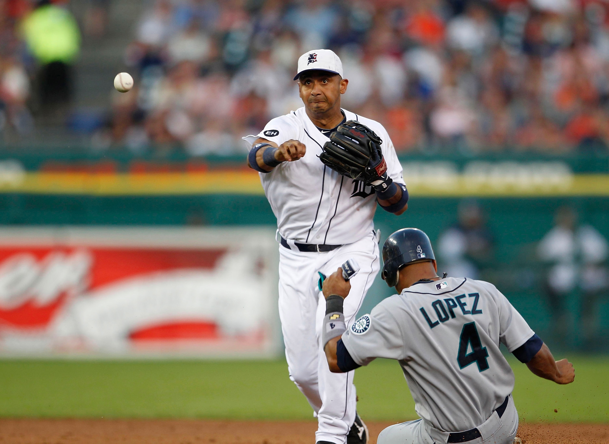 DETROIT - JULY 02: Carlos Guillen #9 of of the Detroit Tigers turns a double play forcing out Jose Lopez #4 of the Seattle Mariners at second base during the seventh inning of the game on July 2, 2010 at Comerica Park in Detroit, Michigan.  The Tigers def