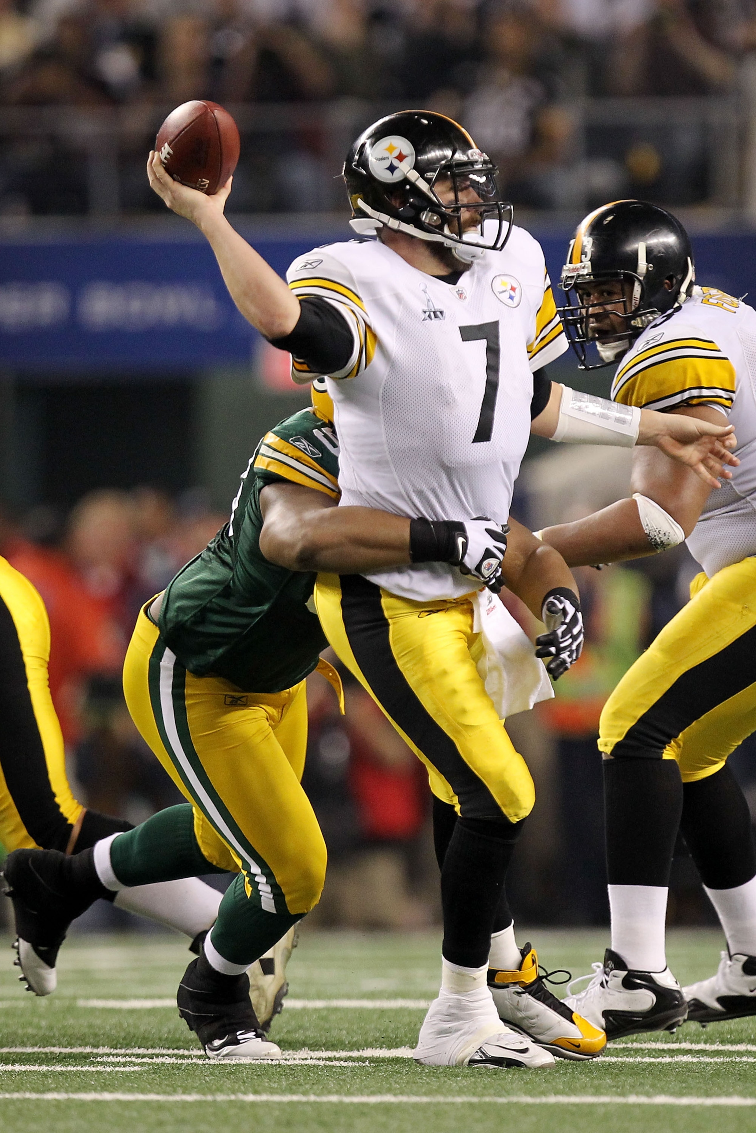 ARLINGTON, TX - FEBRUARY 06:  Ben Roethlisberger #7 of the Pittsburgh Steelers throws the ball as he is hit by a Green Bay Packers defender during Super Bowl XLV at Cowboys Stadium on February 6, 2011 in Arlington, Texas.  (Photo by Ronald Martinez/Getty