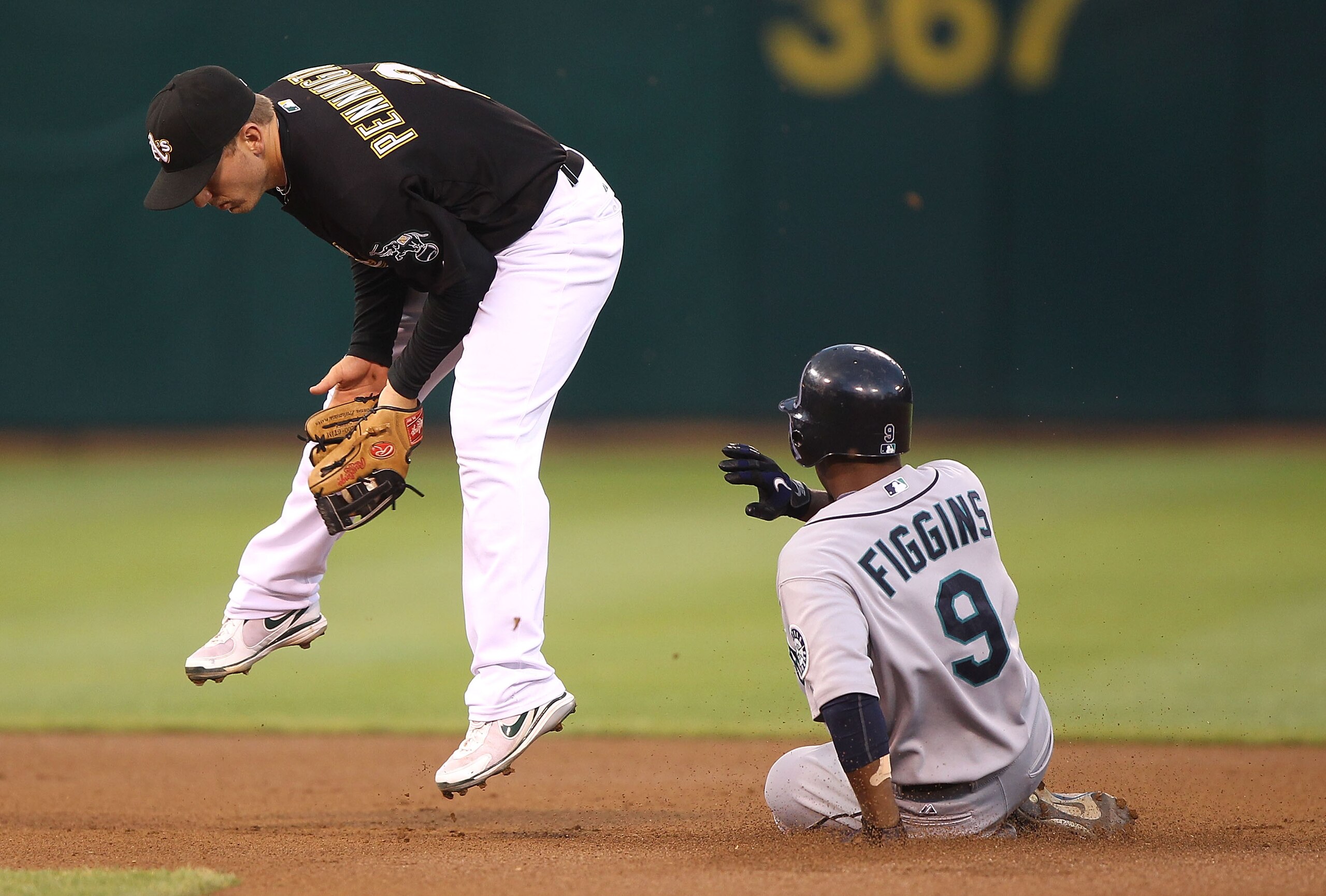 OAKLAND, CA - SEPTEMBER 8:  Chone Figgins #9 of the Seattle Mariners steals second base as Cliff Pennington #2 of  the Oakland Athletics fields the throw in the first inning during a Major League Baseball game at the Oakland-Alameda County Coliseum on Sep