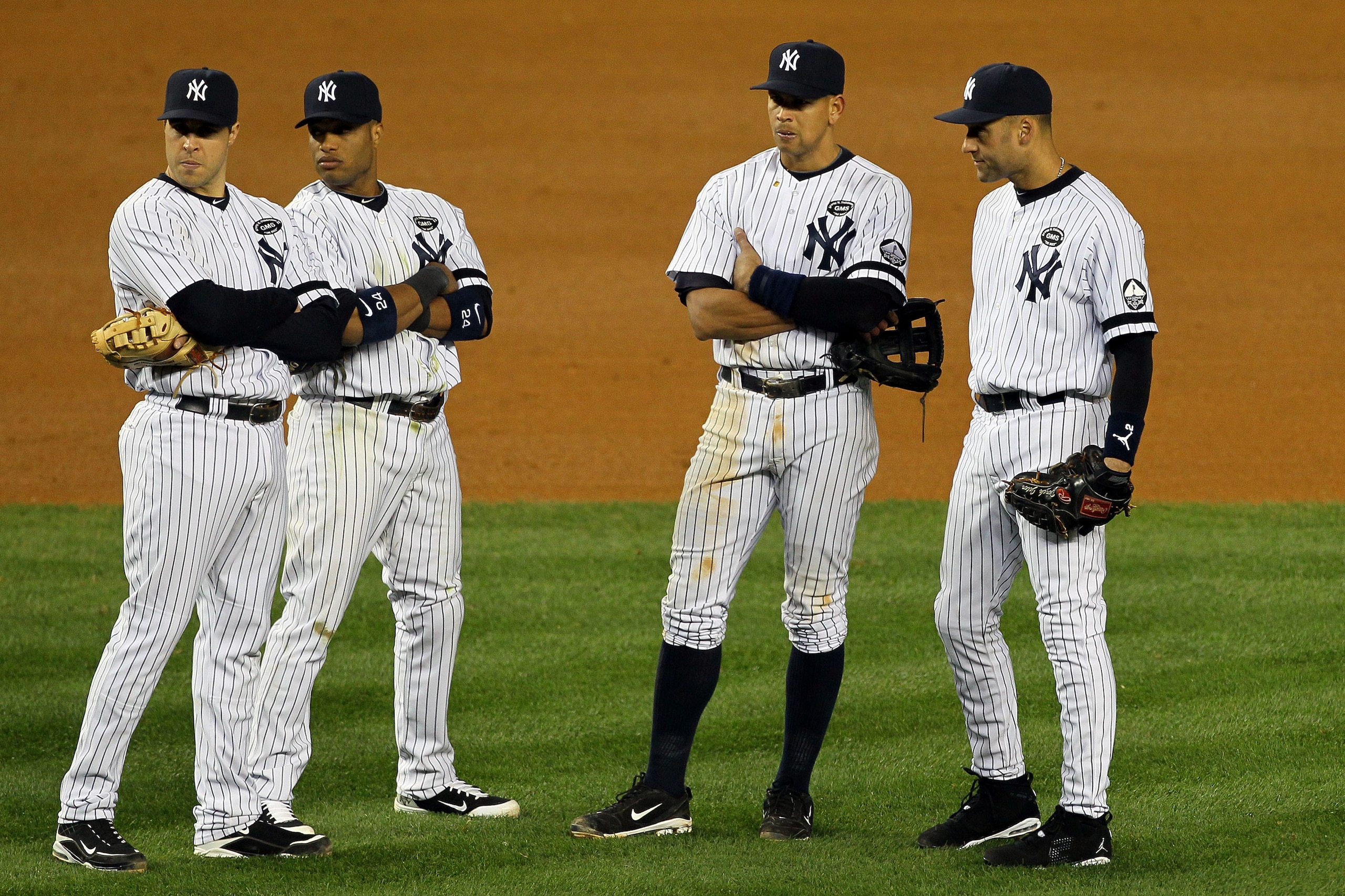 NEW YORK - OCTOBER 18:  Mark Teixeira #25, Robinson Cano #24, Alex Rodriguez #13 and Derek Jeter #2 of the New York Yankees look on during a pitching change against the Texas Rangers in Game Three of the ALCS during the 2010 MLB Playoffs at Yankee Stadium
