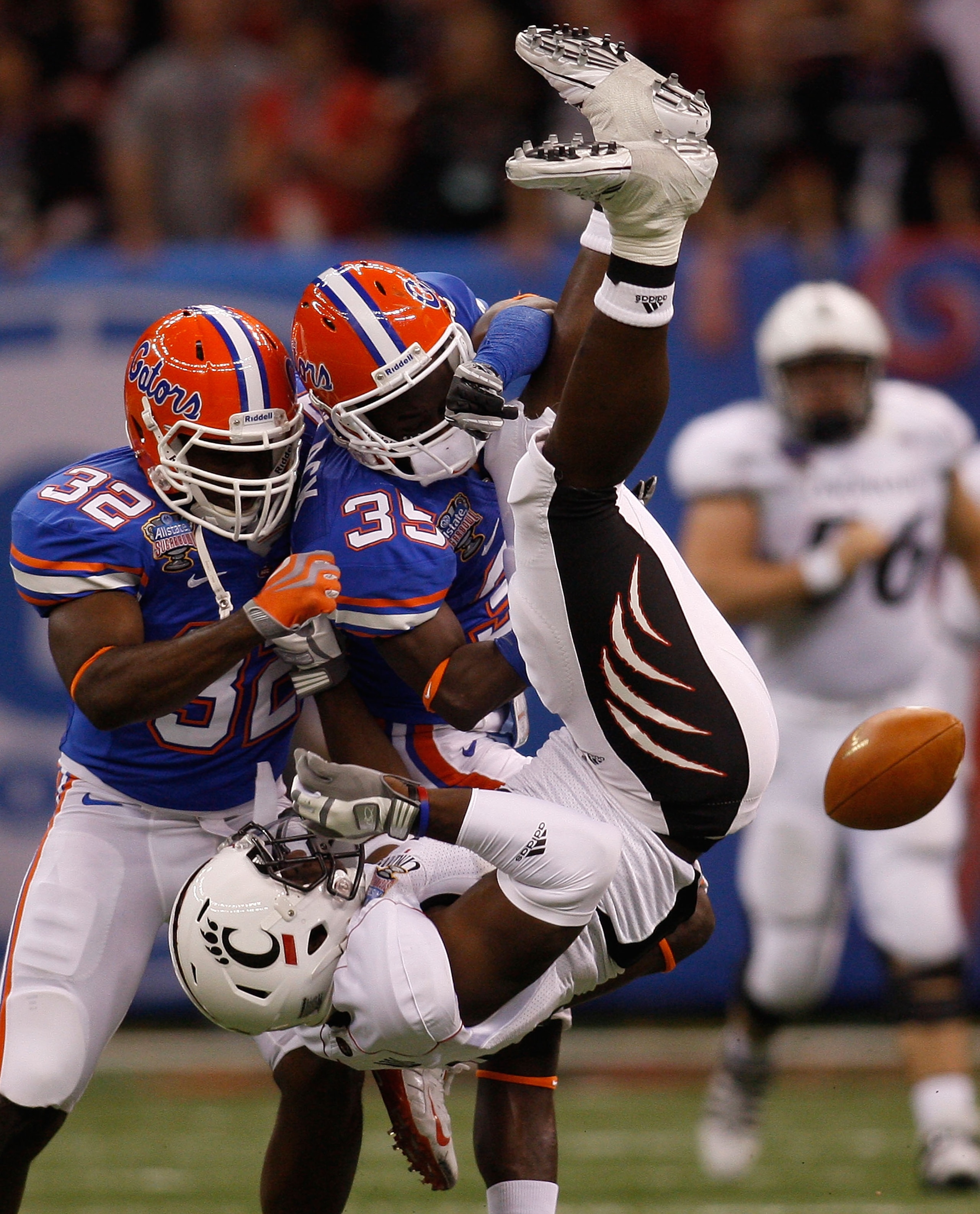 NEW ORLEANS - JANUARY 01:  Deonte Thompson #8 of the Cincinnati Bearcats is flipped upside down by Ahmad Black #35 and Dustin Doe #32 of the Florida Gators during the Allstate Sugar Bowl at the Louisana Superdome on January 1, 2010 in New Orleans, Louisia