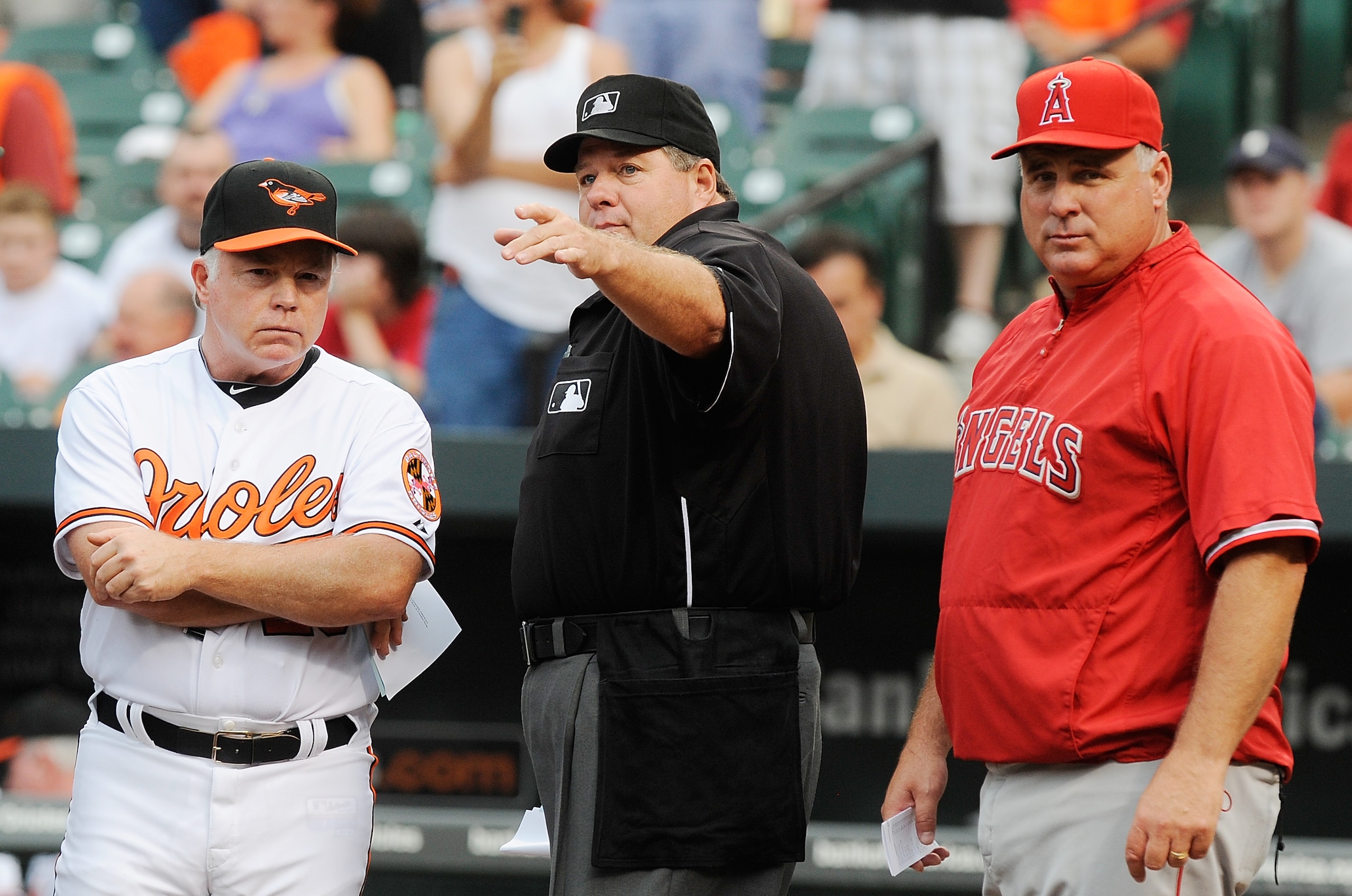 BALTIMORE - AUGUST 03: Home plate Umpire Jerry Layne talks to Manager Buck Showalter of the Baltimore Orioles and Manager Mike Scioscia of the Los Angeles Angels of Anaheim before the game at Camden Yards on August 3, 2010 in Baltimore, Maryland.  (Photo