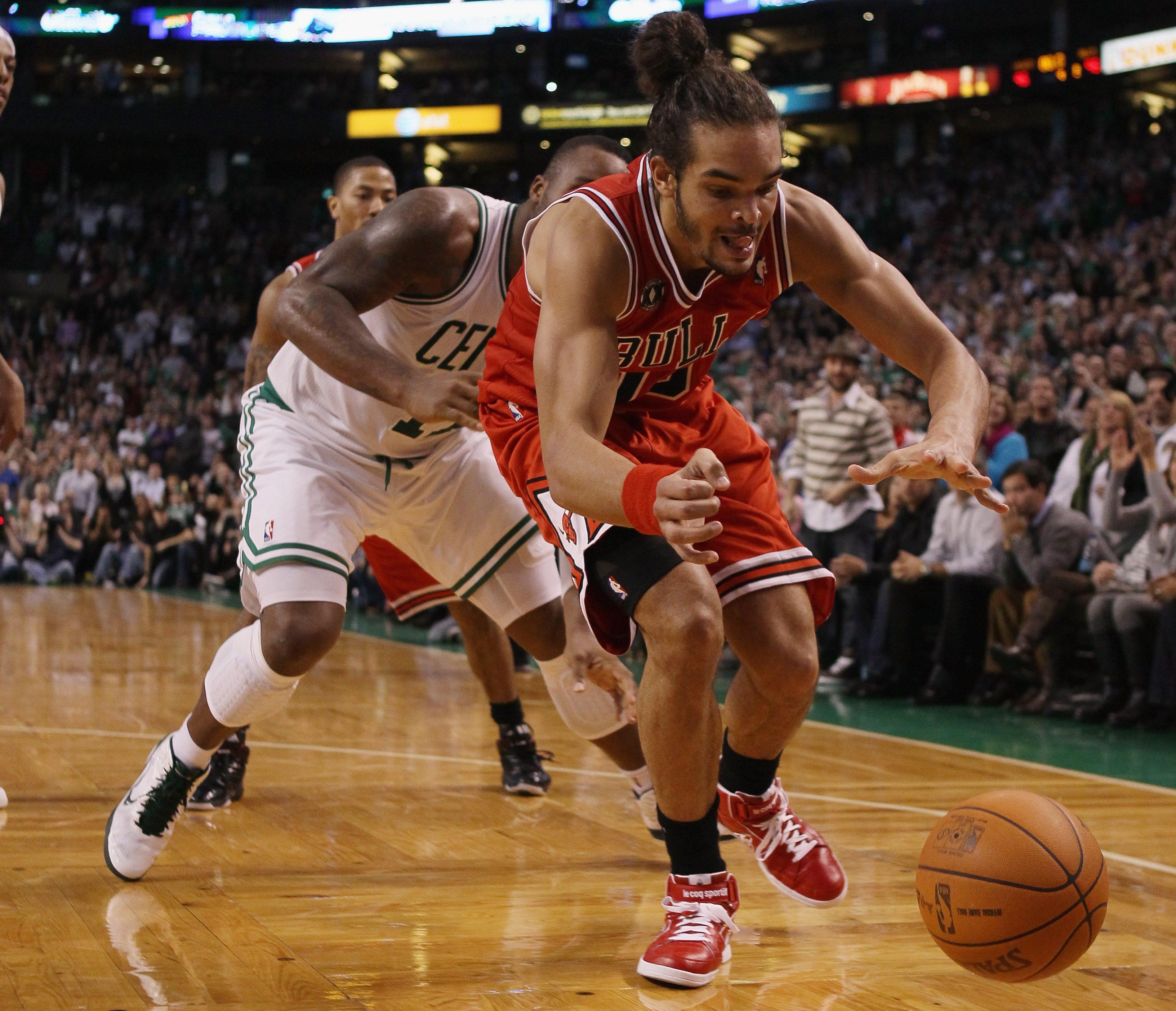 BOSTON - NOVEMBER 05:  Joakim Noah #13 of the Chicago Bulls and Glen Davis #11 of the Boston Celtics chase after a loose ball on November 5, 2010 at the TD Garden in Boston, Massachusetts. The Celtics defeated the Bulls 110-105 in overtime. NOTE TO USER: