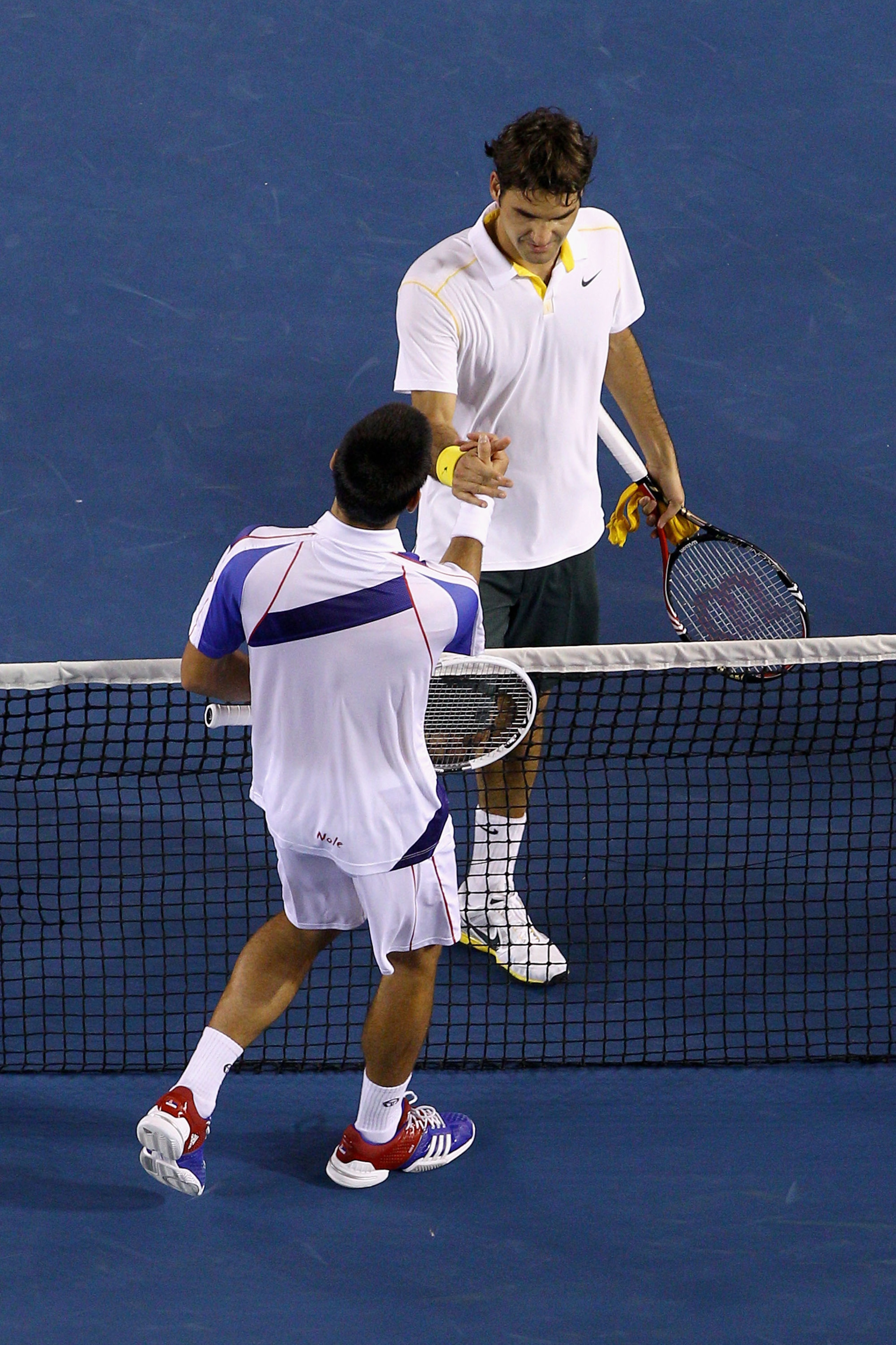 MELBOURNE, AUSTRALIA - JANUARY 27:  Roger Federer of Switzerland congratulates Novak Djokovic of Serbia after their semifinal match during day eleven of the 2011 Australian Open at Melbourne Park on January 27, 2011 in Melbourne, Australia.  (Photo by Qui
