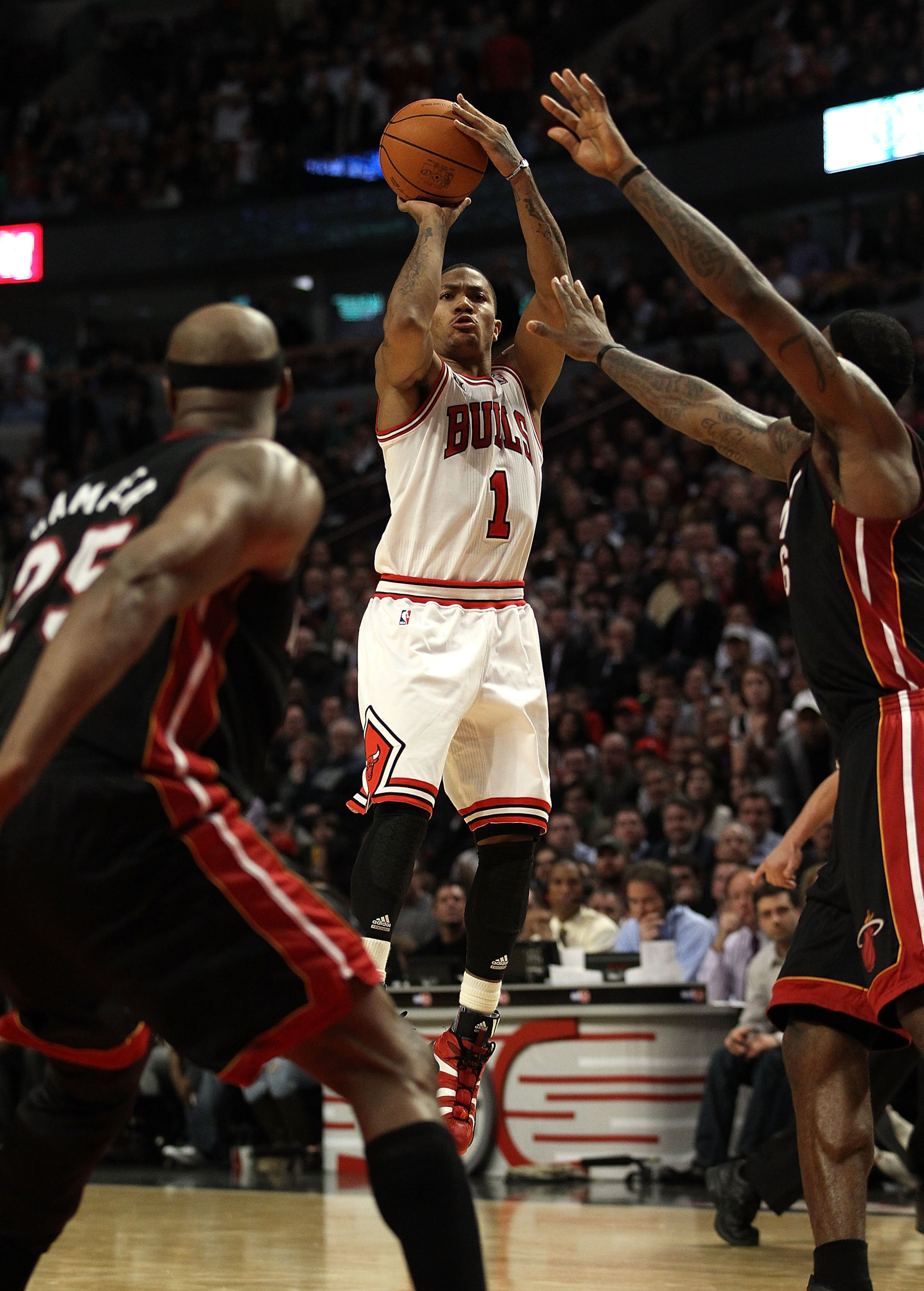 CHICAGO, IL - FEBRUARY 24: Derrick Rose #1 of the Chicago Bulls puts up a shot between Eric Dampier #25 (L) and LeBron James #6 of the Miami Heat at the United Center on February 24, 2011 in Chicago, Illinois. The Bulls defeated the Heat 93-89. NOTE TO US