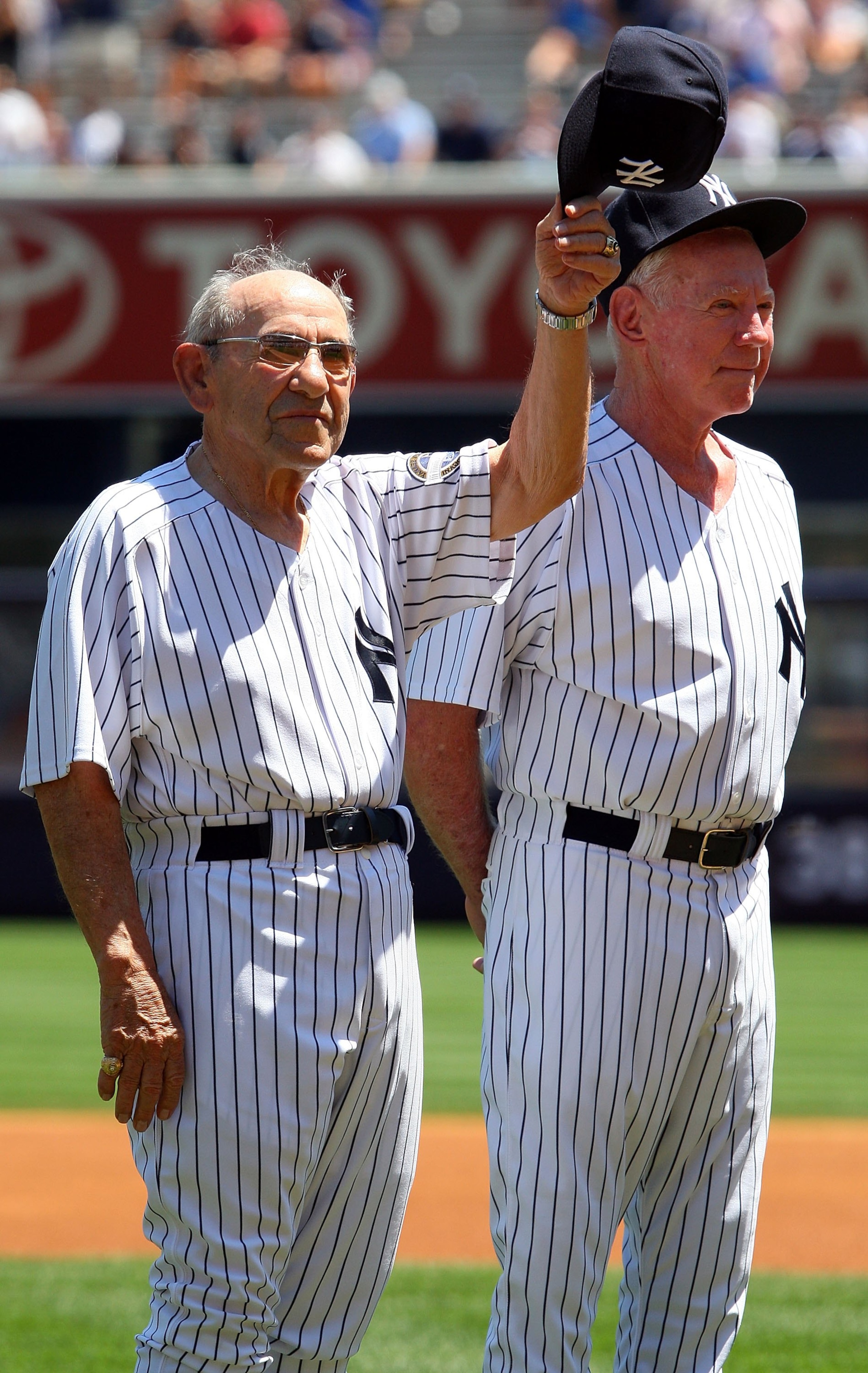 NEW YORK - JULY 19:  New York Yankees Hall of Famer Yogi Berra tips his cap to the crowd during the teams 63rd Old Timers Day as Whitey Ford looks on before the game against the Detroit Tigers on July 19, 2009 at Yankee Stadium in the Bronx borough of New