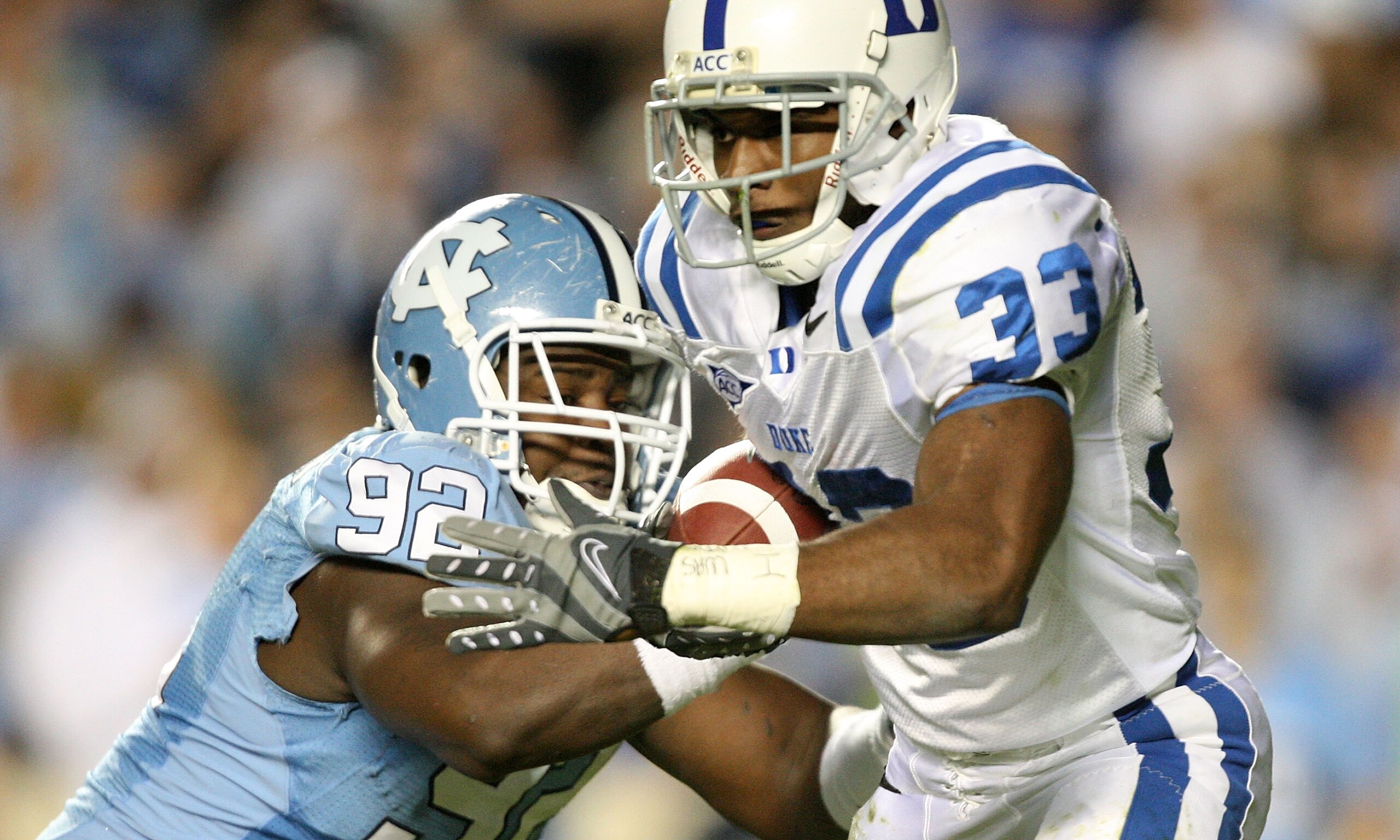 CHAPEL HILL, NC - NOVEMBER 07:  Desmond Scott #33 of the Duke Blue Devils is tackled by E.J. Wilson #92 of the North Carolina Tar Heels during their game at Kenan Stadium on November 7, 2009 in Chapel Hill, North Carolina.  (Photo by Streeter Lecka/Getty