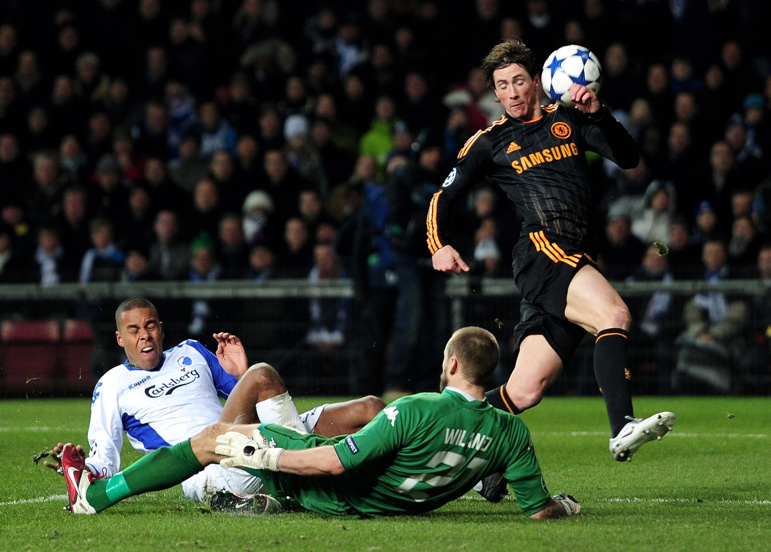 COPENHAGEN, DENMARK - FEBRUARY 22:  Fernando Torres of Chelsea is challenged by Mathias Zanka Jorgensen (L) and Johan Wiland of FC Copenhagen during  the UEFA Champions League round of 16 first leg match between FC Copenhagen and Chelsea at Parken Stadium