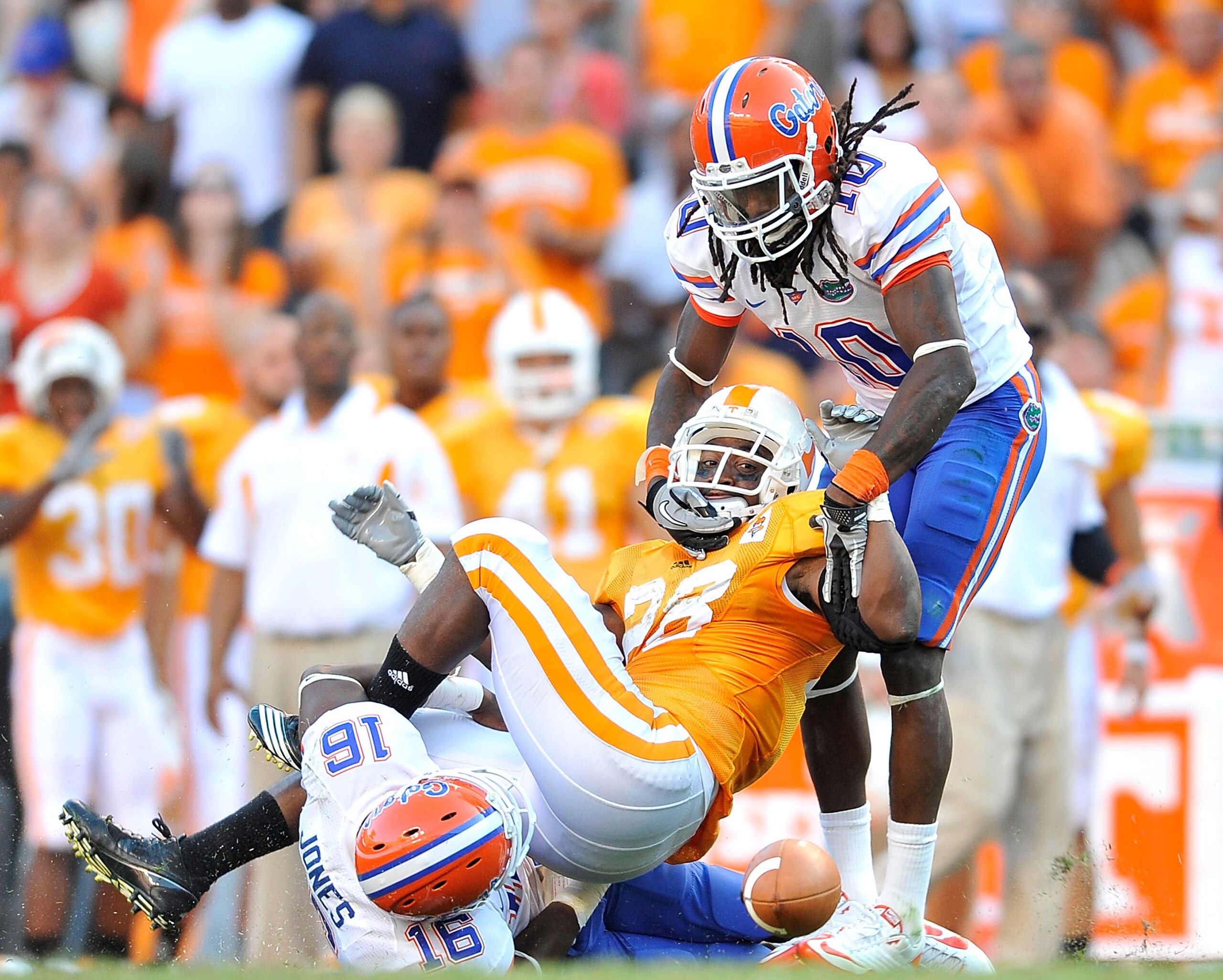 KNOXVILLE, TN - SEPTEMBER 18:  Will Hill #10 and A.J. Jones #16 of the Florida Gators force a fumble by Tauren Poole #28 of the Tennessee Volunteers late in the fourth quarter at Neyland Stadium on September 18, 2010 in Knoxville, Tennessee. Florida won 3