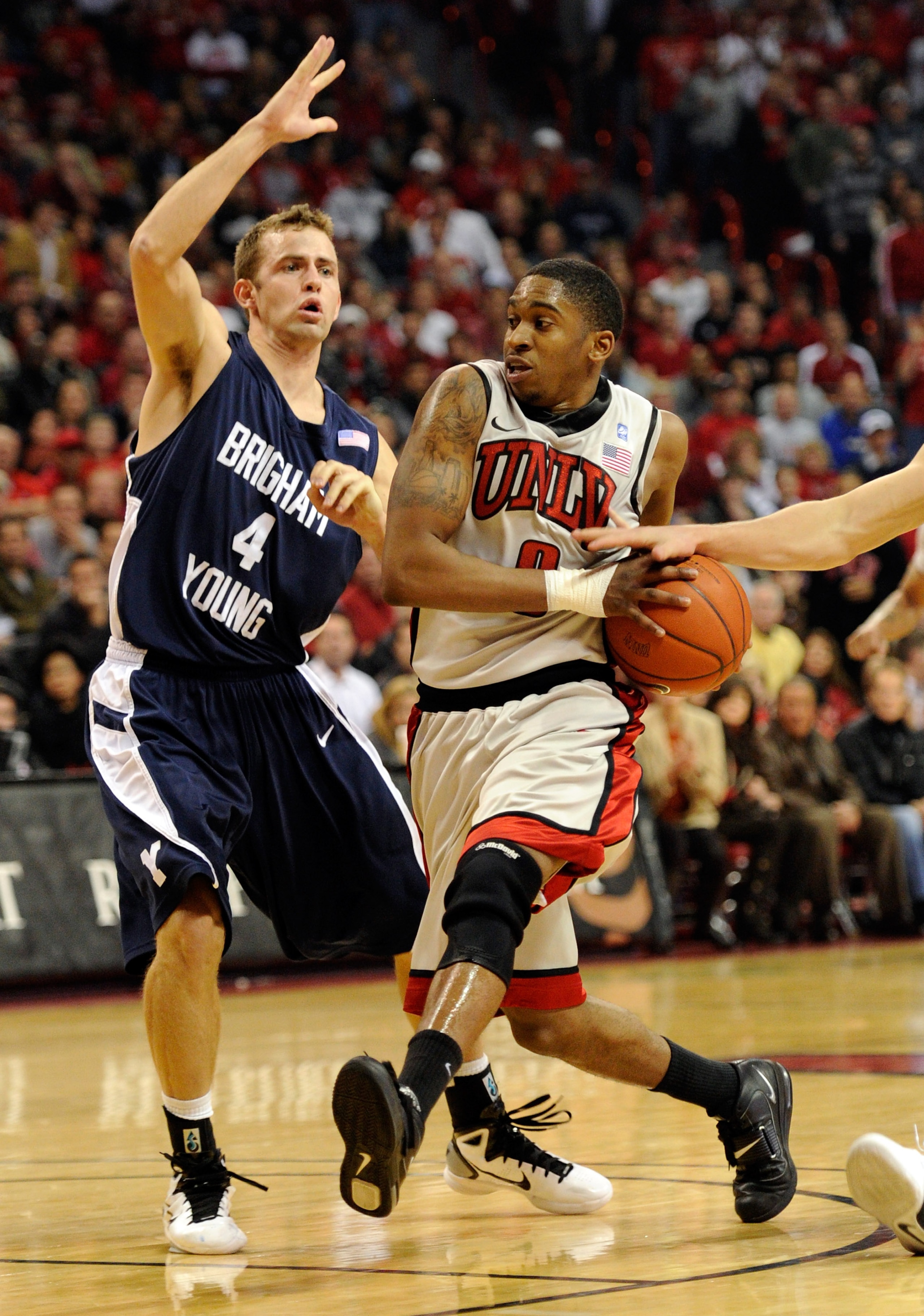LAS VEGAS, NV - JANUARY 05:  Oscar Bellfield #0 of the UNLV Rebels has the ball knocked away from behind as he drives against Jackson Emery #4 of the Brigham Young University Cougars during their game at the Thomas & Mack Center January 5, 2011 in Las Veg