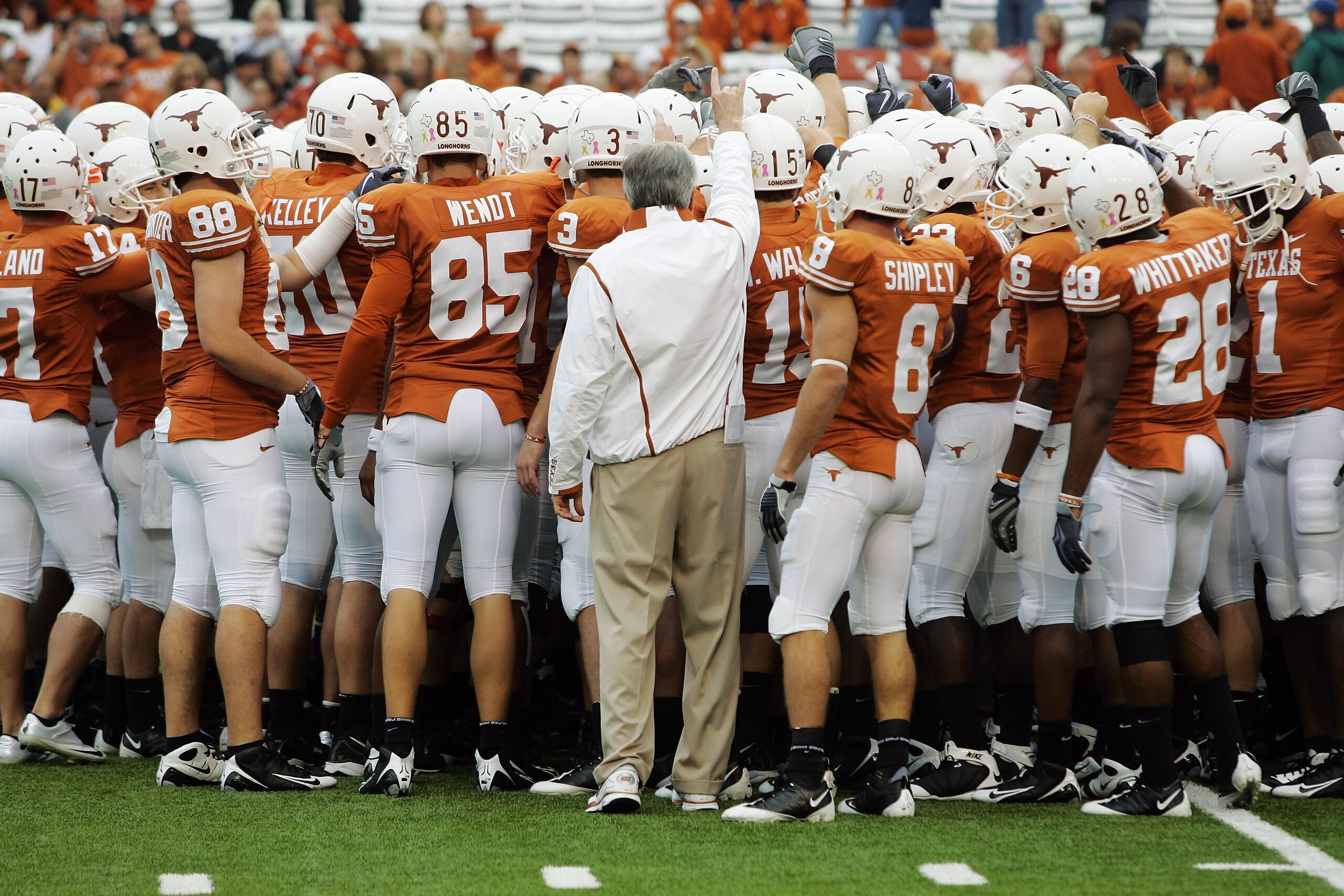 AUSTIN, TX - OCTOBER 10: Head coach Mack Brown of the Texas Longhorns joins his team in a huddle before a game against the Colorado Buffaloes on October 10, 2009 at Darrell K Royal-Texas Memorial Stadium in Austin, Texas.  Texas won 38-14.  (Photo by Bria