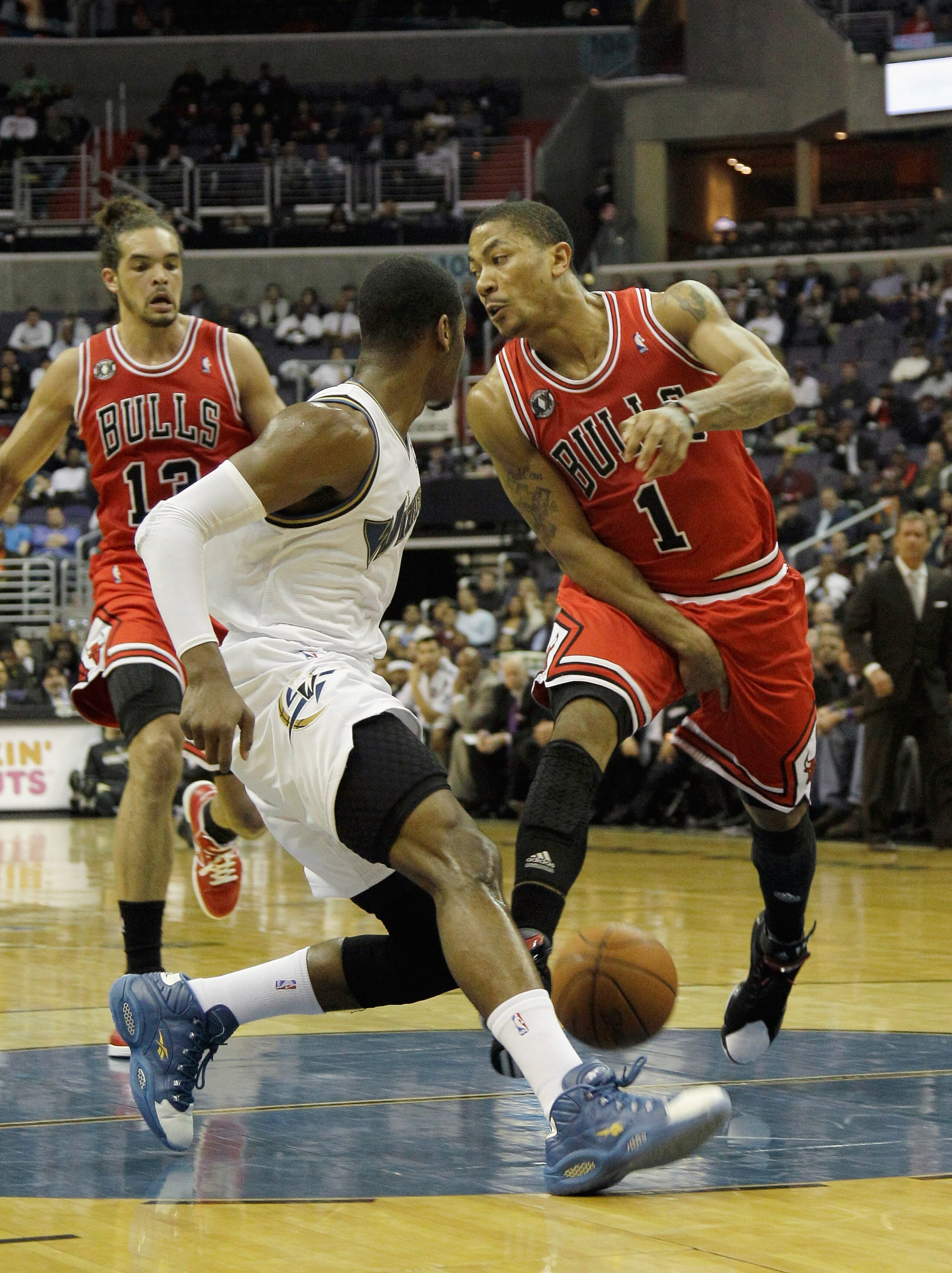 WASHINGTON, DC - FEBRUARY 28:  Derrick Rose #1 of the Chicago Bulls passes the ball between his legs back to teammate Joakim Noah #13 as John Wall #2 of the Washington Wizards guards him at the Verizon Center in Washington on February 28, 2011 in Washingt