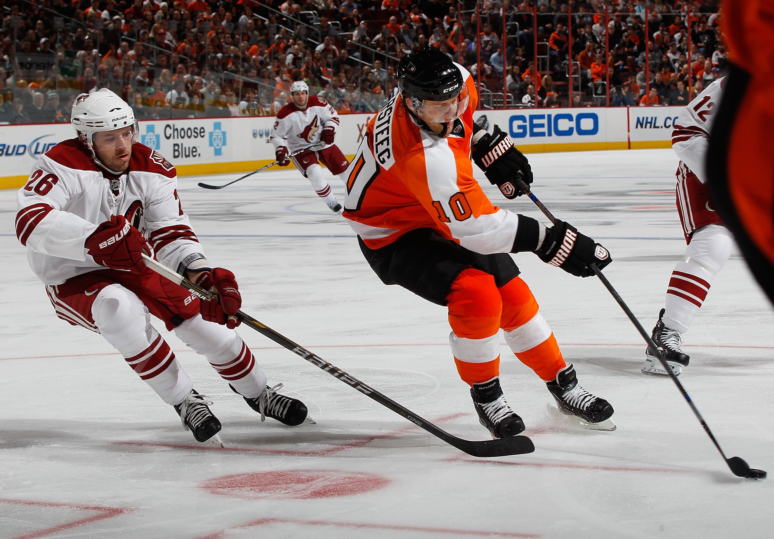 PHILADELPHIA - FEBRUARY 22:   Kris Versteeg #10 of the Philadelphia Flyers plays the puck in front of Andrew Ebbett #26 of the Phoenix Coyotes on February 22, 2011 at the Wells Fargo Center in Philadelphia, Pennsylvania. Coyotes defeat the Flyers 3-2 in O