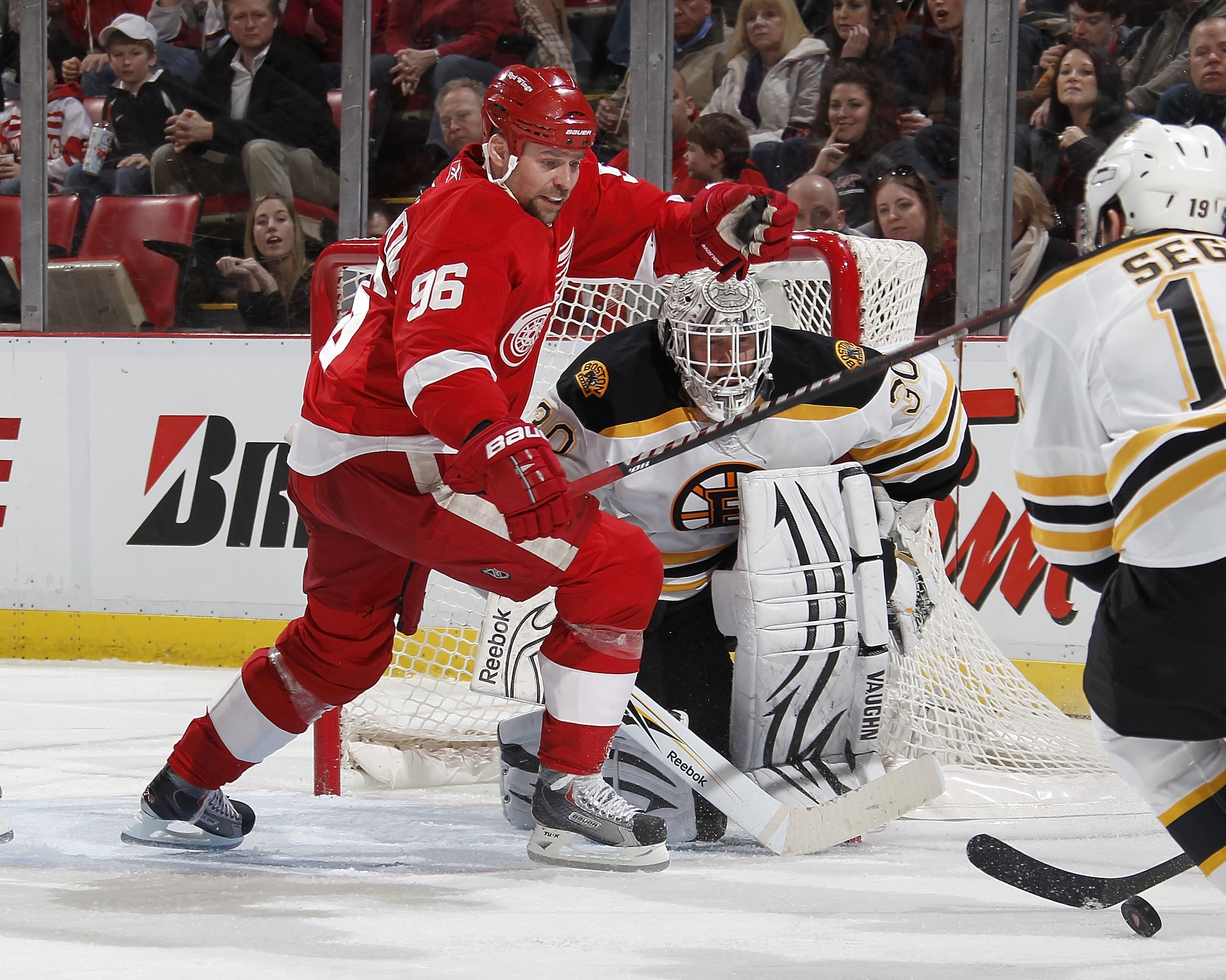 DETROIT, MI - FEBRUARY 13:  Tomas Holmstrom #96 of the Detroit Red Wings tries to get to the puck in front of Tim Thomas #30 of the Boston Bruins on February 13, 2011 at Joe Lewis Arena in Detroit, Michigan.  (Photo by Gregory Shamus/Getty Images)