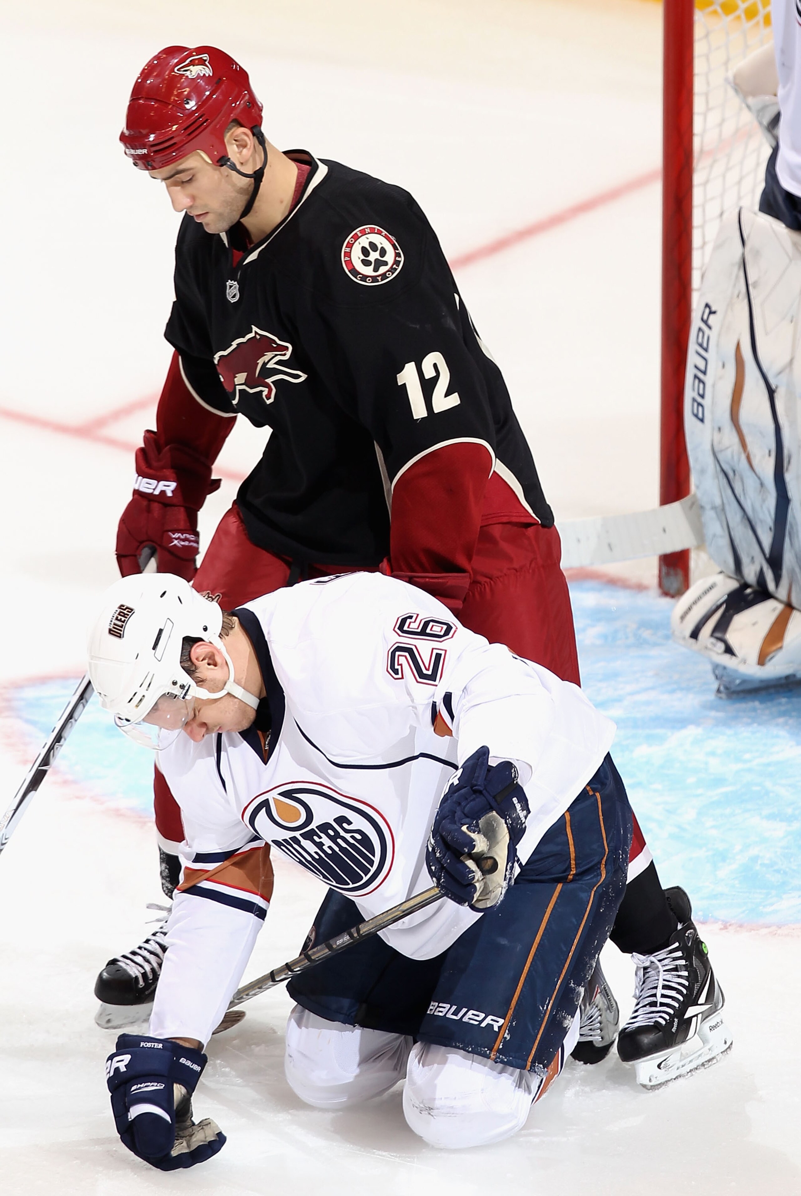 GLENDALE, AZ - JANUARY 25:  Paul Bissonnette #12 of the Phoenix Coyotes stands over Kurtis Foster #26 of the Edmonton Oilers during the NHL game at Jobing.com Arena on January 25, 2011 in Glendale, Arizona.  The Oilers defeated the Coyotes 4-3.  (Photo by