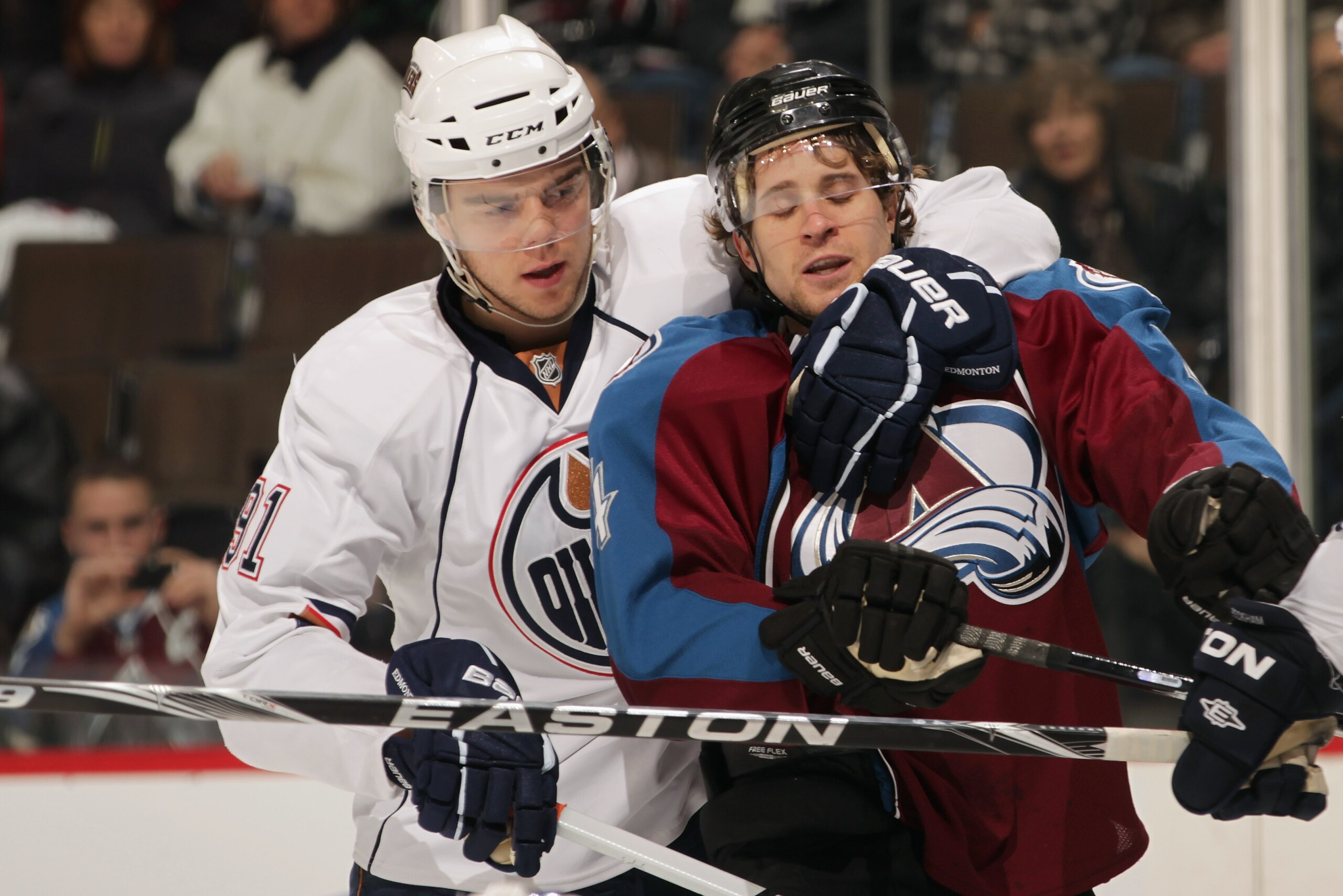 DENVER, CO - FEBRUARY 23:  John-Michael Liles #4 of the Colorado Avalanche is restrained by Magnsu Paajarvi #91 of the Edmonton Oilers at the Pepsi Center on February 23, 2011 in Denver, Colorado. Elliott collected the loss as the Oilers defeated the Avla