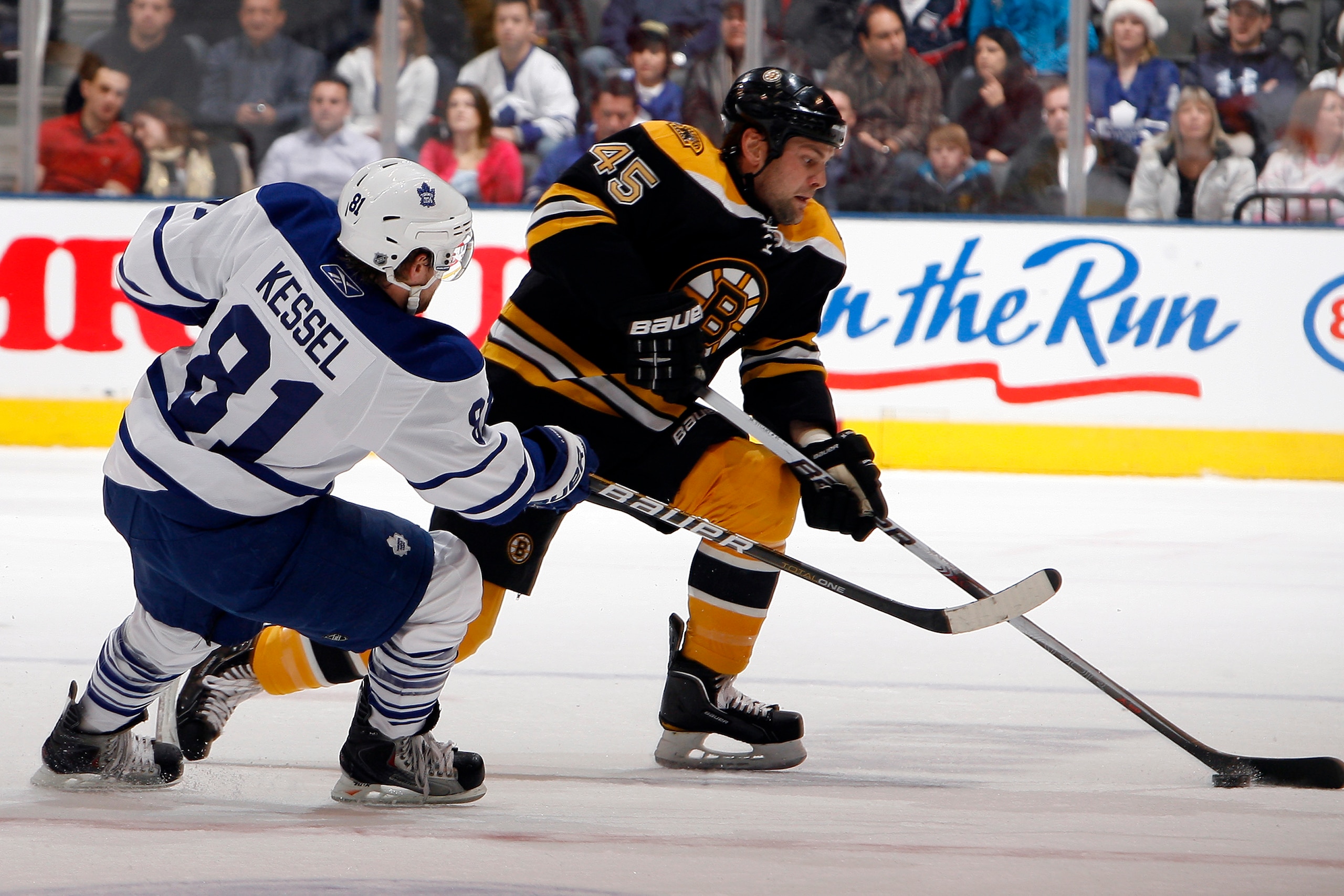 TORONTO, CANADA - DECEMBER 4: Phil Kessel #81 of the Toronto Maple Leafs battles for the puck with Mark Stuart #45 of the Boston Bruins during game action at the Air Canada Centre December 4, 2010 in Toronto, Ontario, Canada. (Photo by Abelimages / Getty