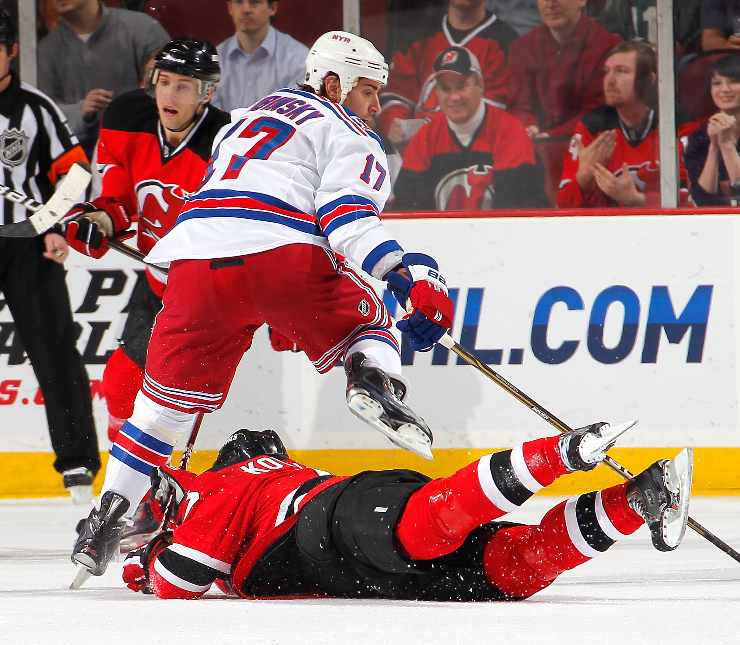 NEWARK, NJ - FEBRUARY 18:  Brandon Dubinsky #17 of the New York Rangers has to step over Ilya Kovalchuk #17 of the New Jersey Devils as he slides on the ice during the third period of an NHL hockey game at the Prudential Center on February 18, 2011 in New