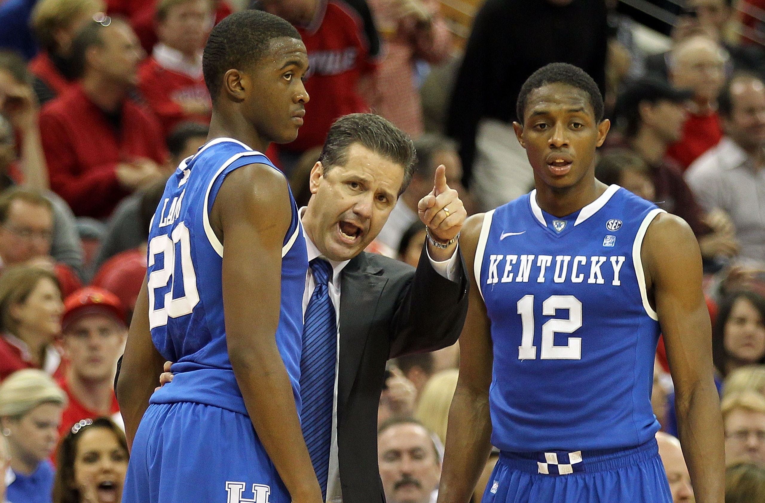 LOUISVILLE, KY - DECEMBER 31:  John Calipari the Head Coach of the Kentucky Wildcats gives instructions to Doron Lamb #20 and Brandon Knight #12 during the game against the Louisville Cardinals at the KFC Yum! Center on December 31, 2010 in Louisville, Ke