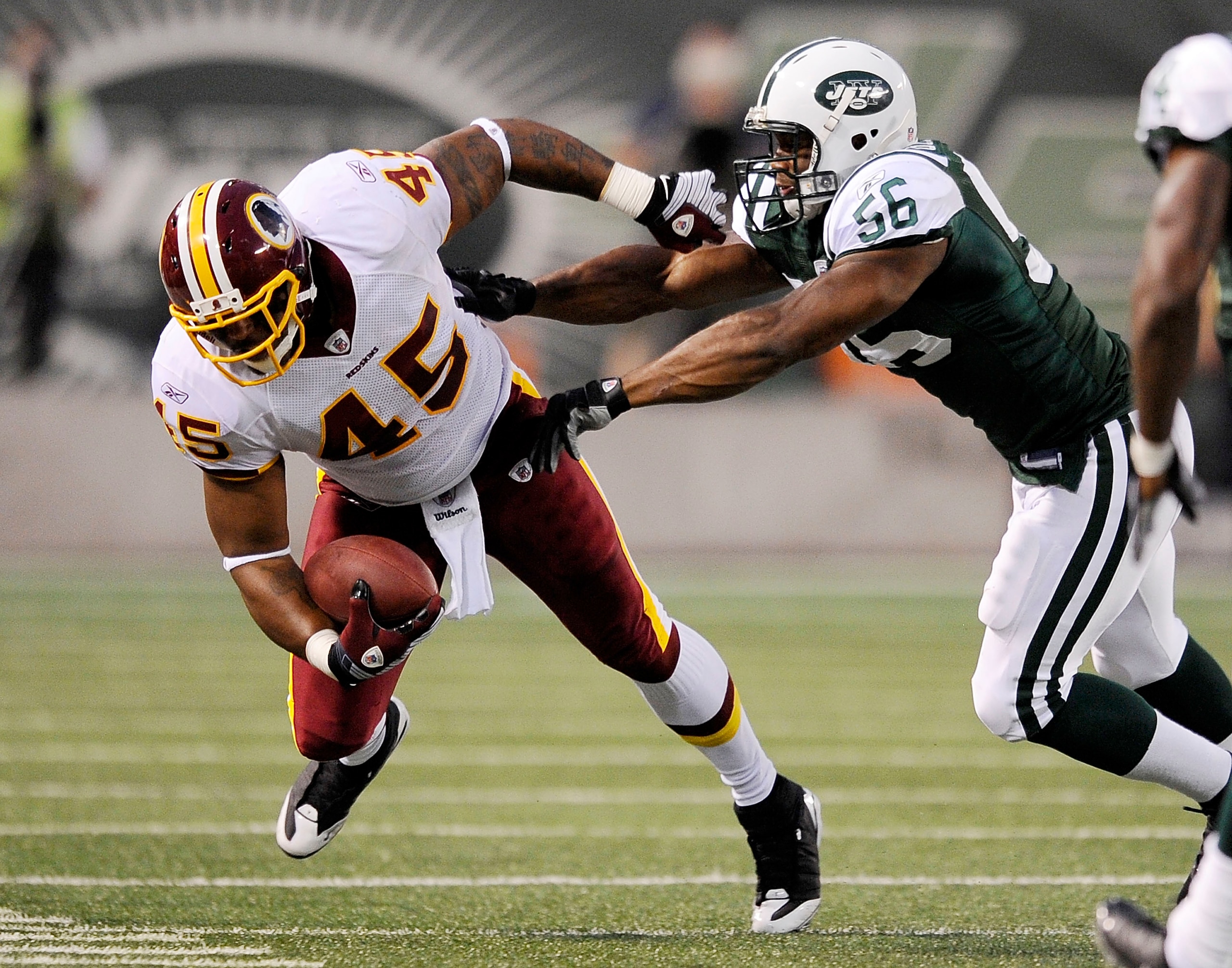 EAST RUTHERFORD, NJ - AUGUST 16:  Vernon Gholston #56 of the New York Jets  takes down Mike Sellers #45 of the Washington Redskins in a pre-season NFL game at Giants Stadium, August 16, 2008 in East Rutherford, New Jersey.  (Photo by Jeff Zelevansky/Getty